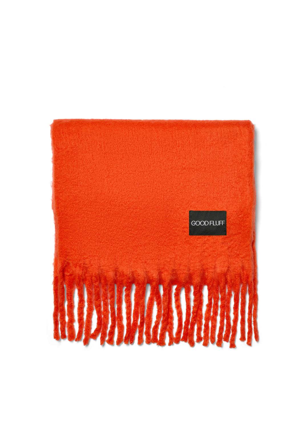 Bright fiery orange scarf with fringes and a black label on a white background