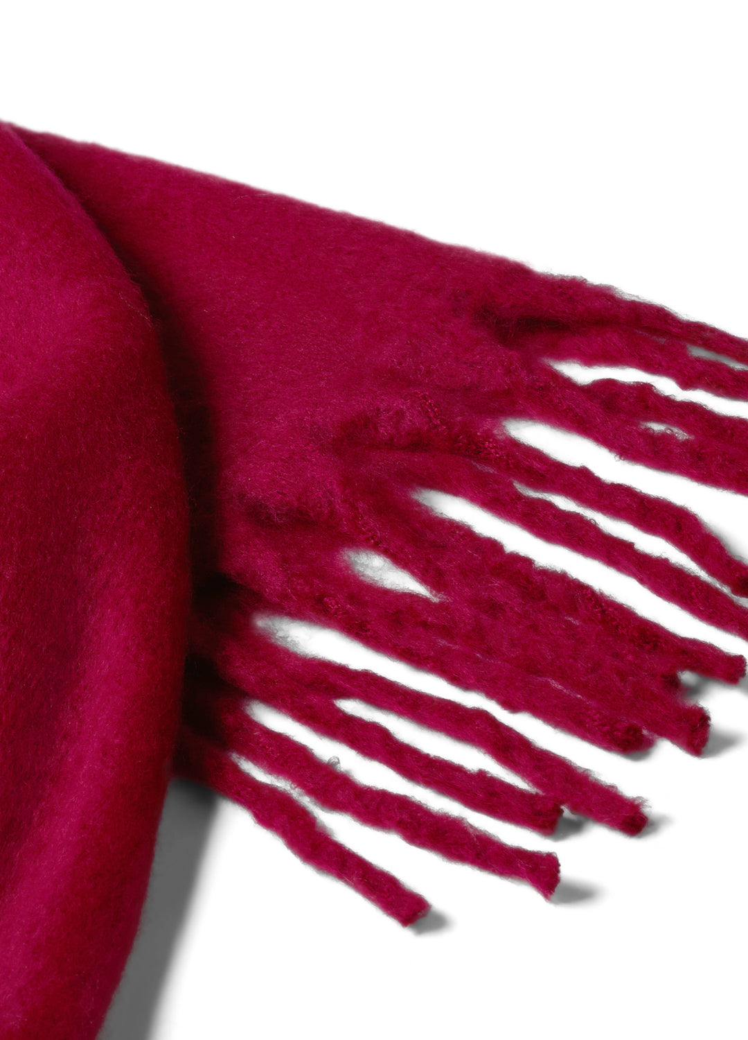 Close-up of a cherry red scarf with fringes on a white background
