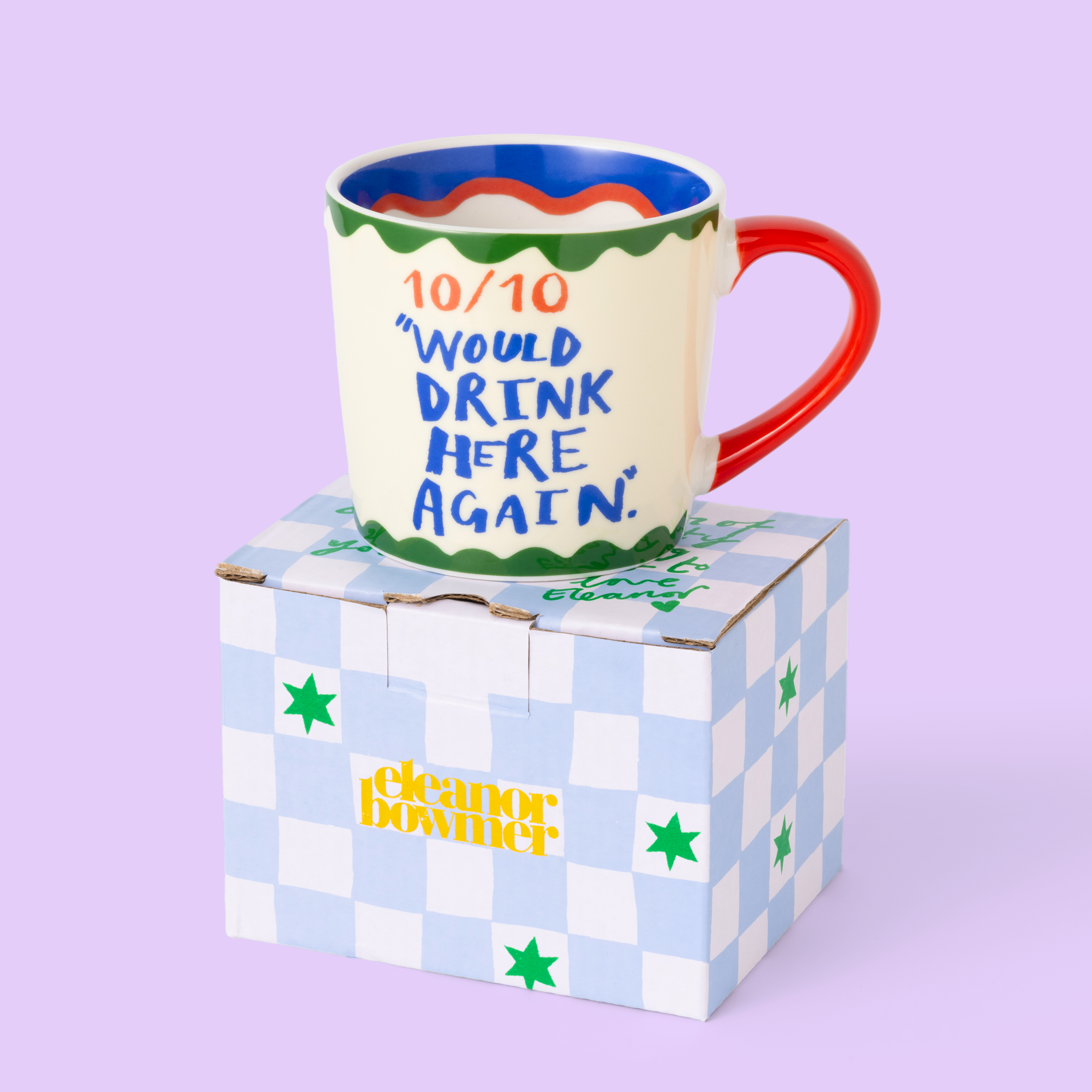 Colourful mug with text on a checkered box against a light purple background
