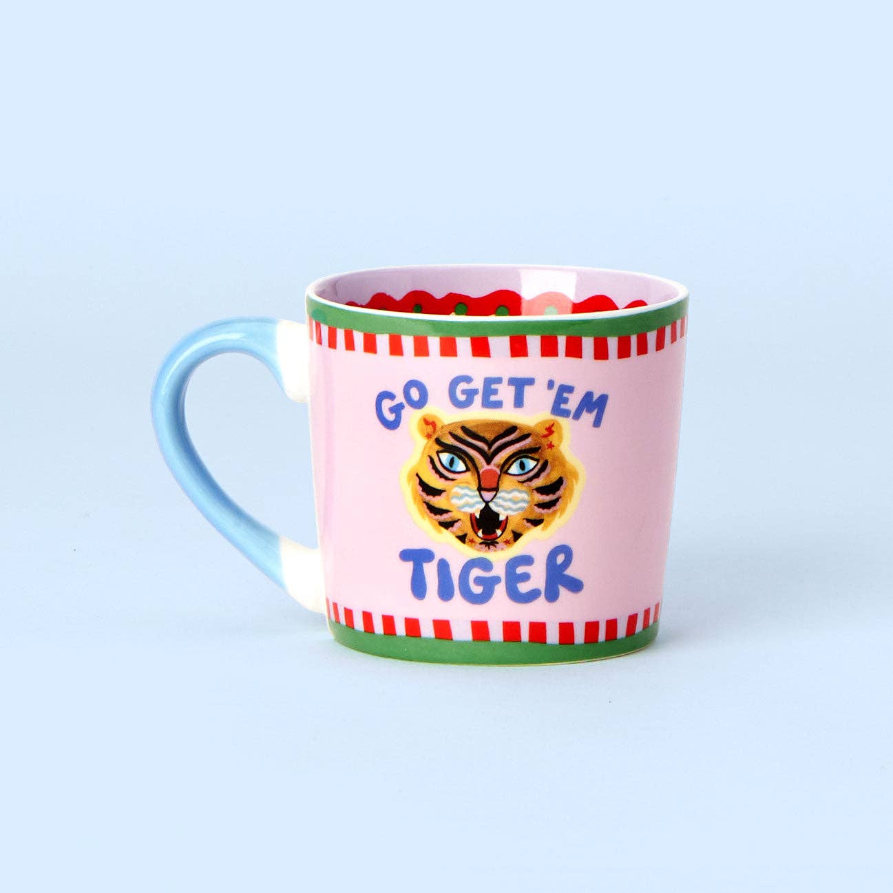 Pink mug with tiger design and 'Go Get 'Em Tiger' text on a light blue background