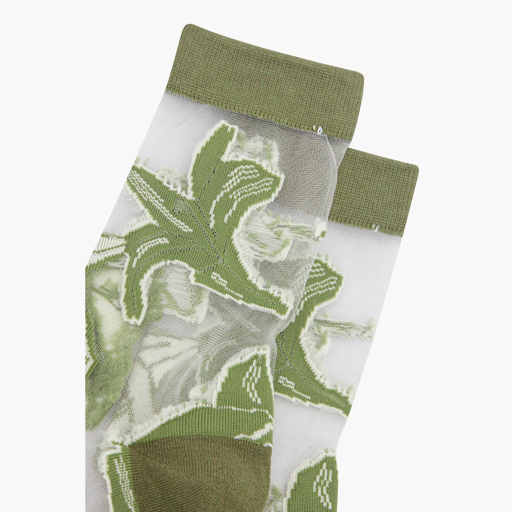 Green dinosaur-themed socks on a white background