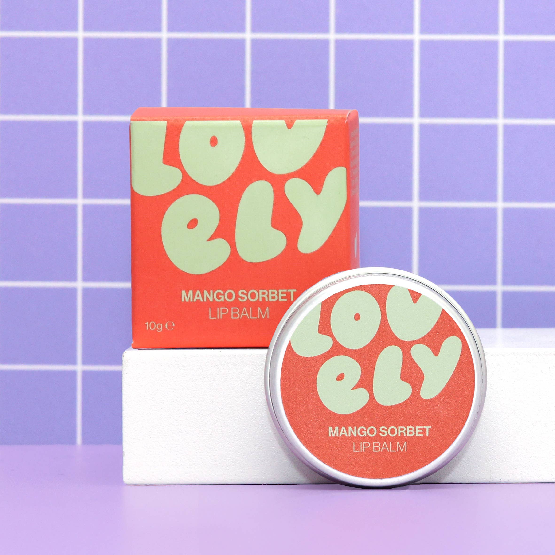 Lovelelly mango sorbet lip balm with packaging on a purple grid background