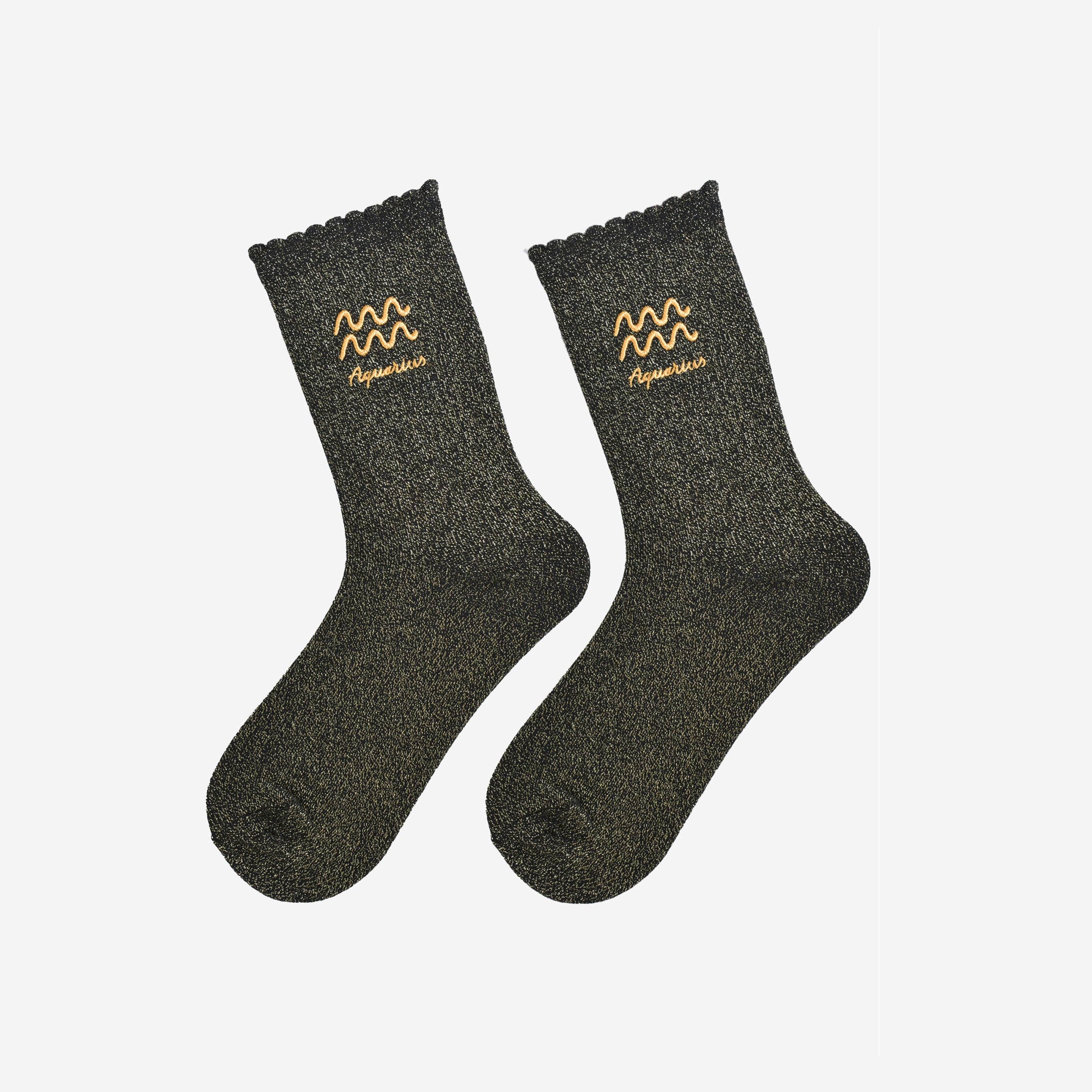 Pair of dark gray socks with Aquarius zodiac sign embroidery on a light gray background