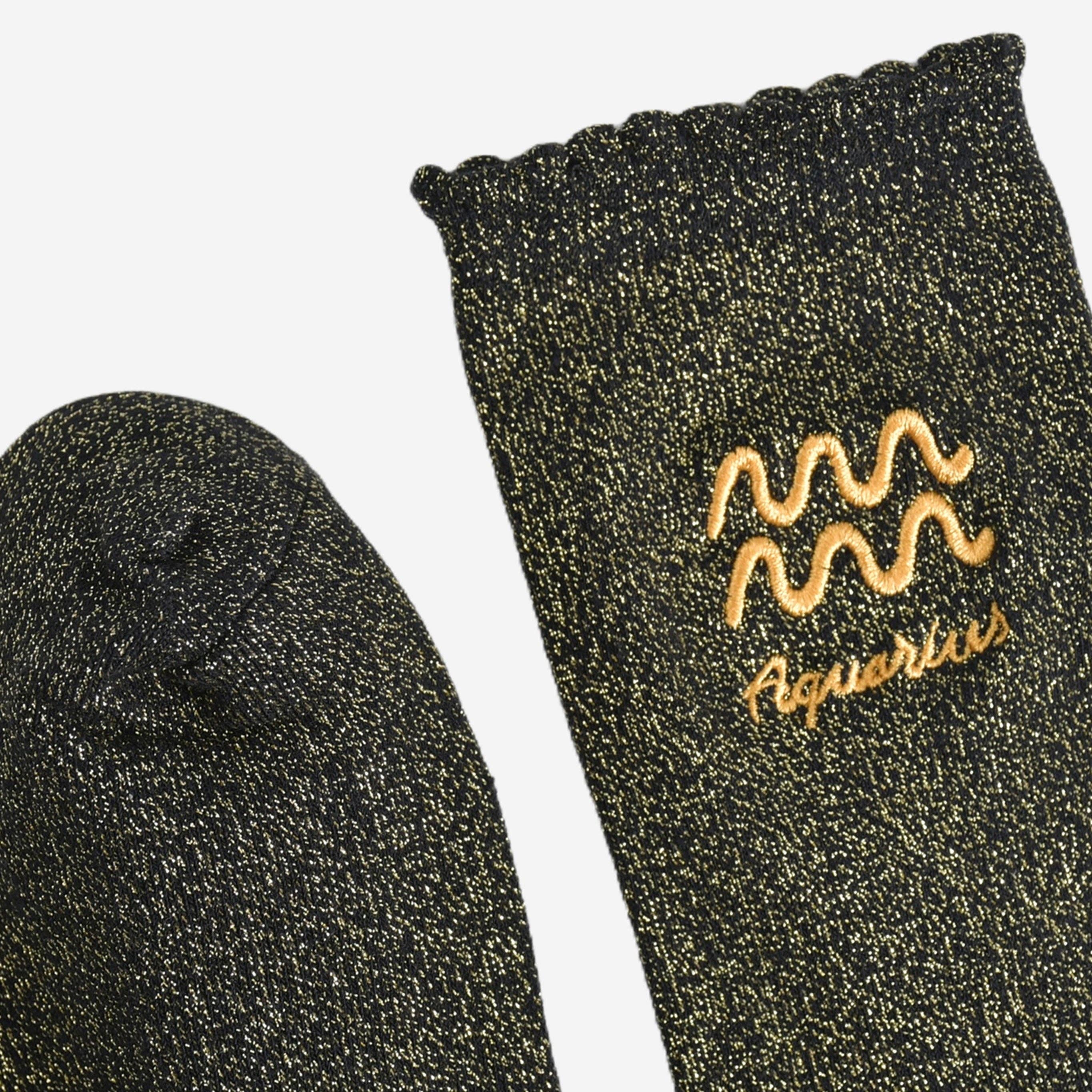 Black socks with gold embroidery on a white background