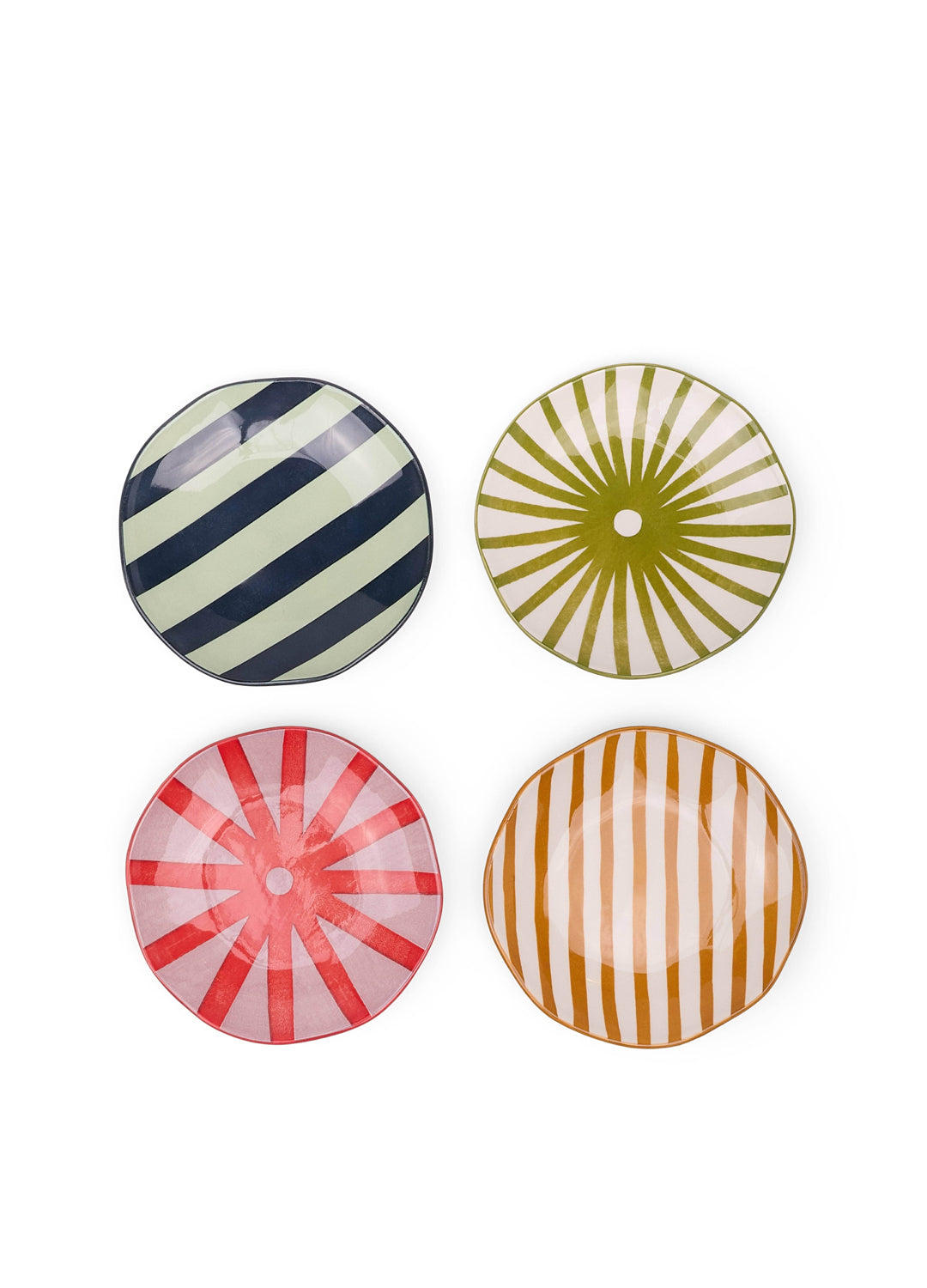 Four colorful ceramic plates with striped and sunburst patterns on a white background