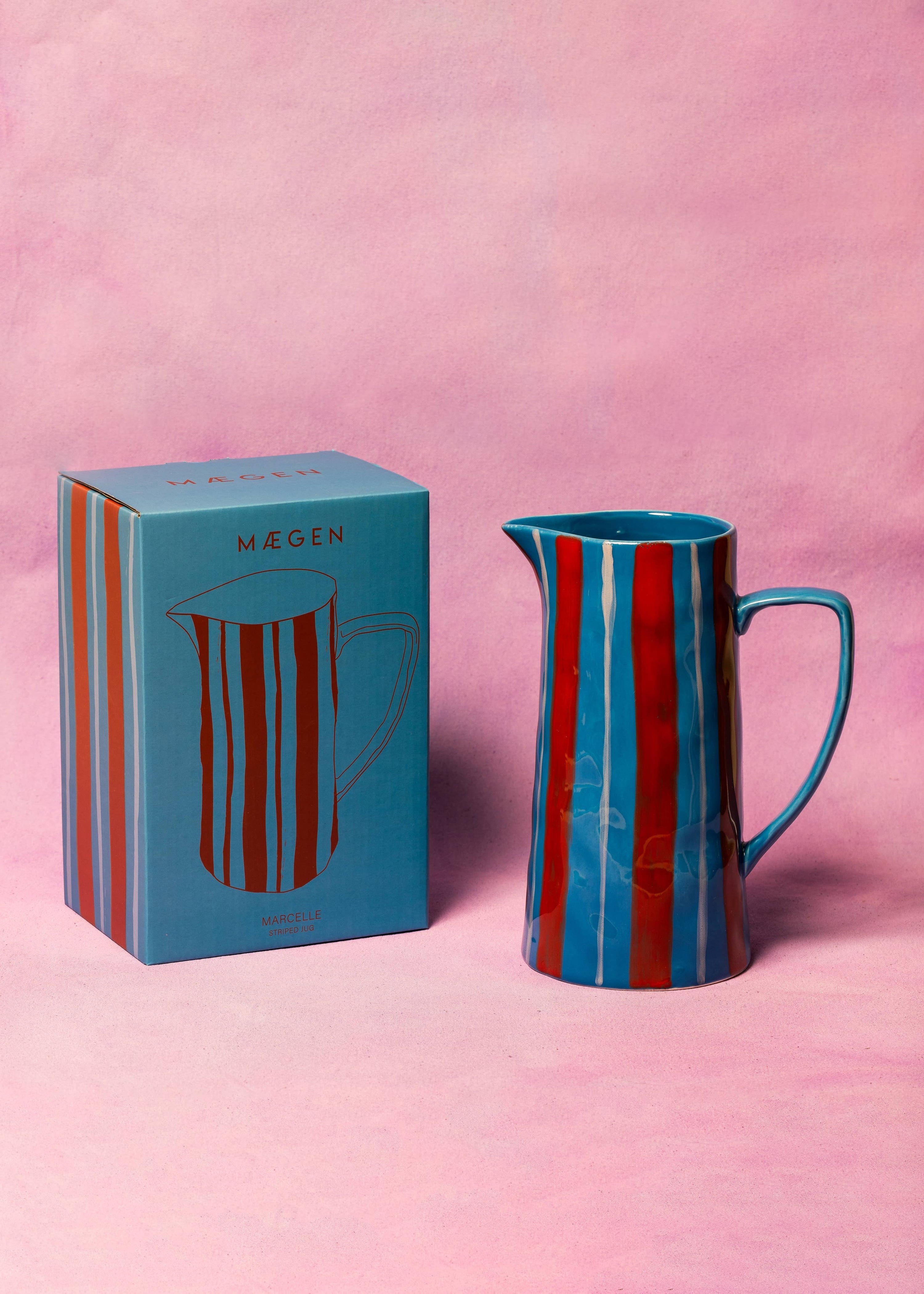 Blue and red striped pitcher with matching box on a pink background