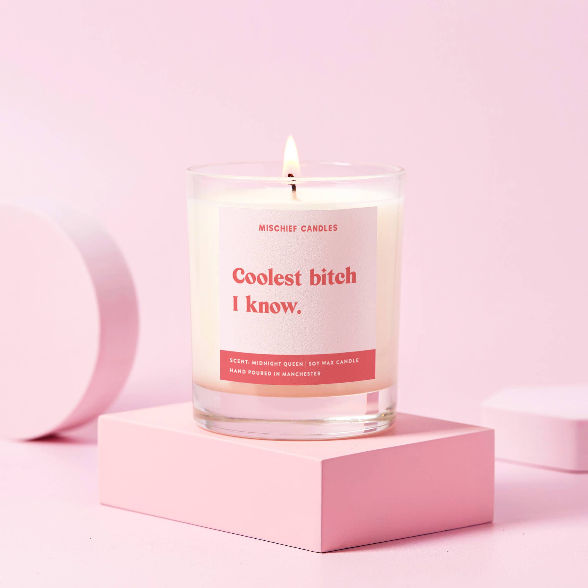 Candle with a humorous label on a pink background