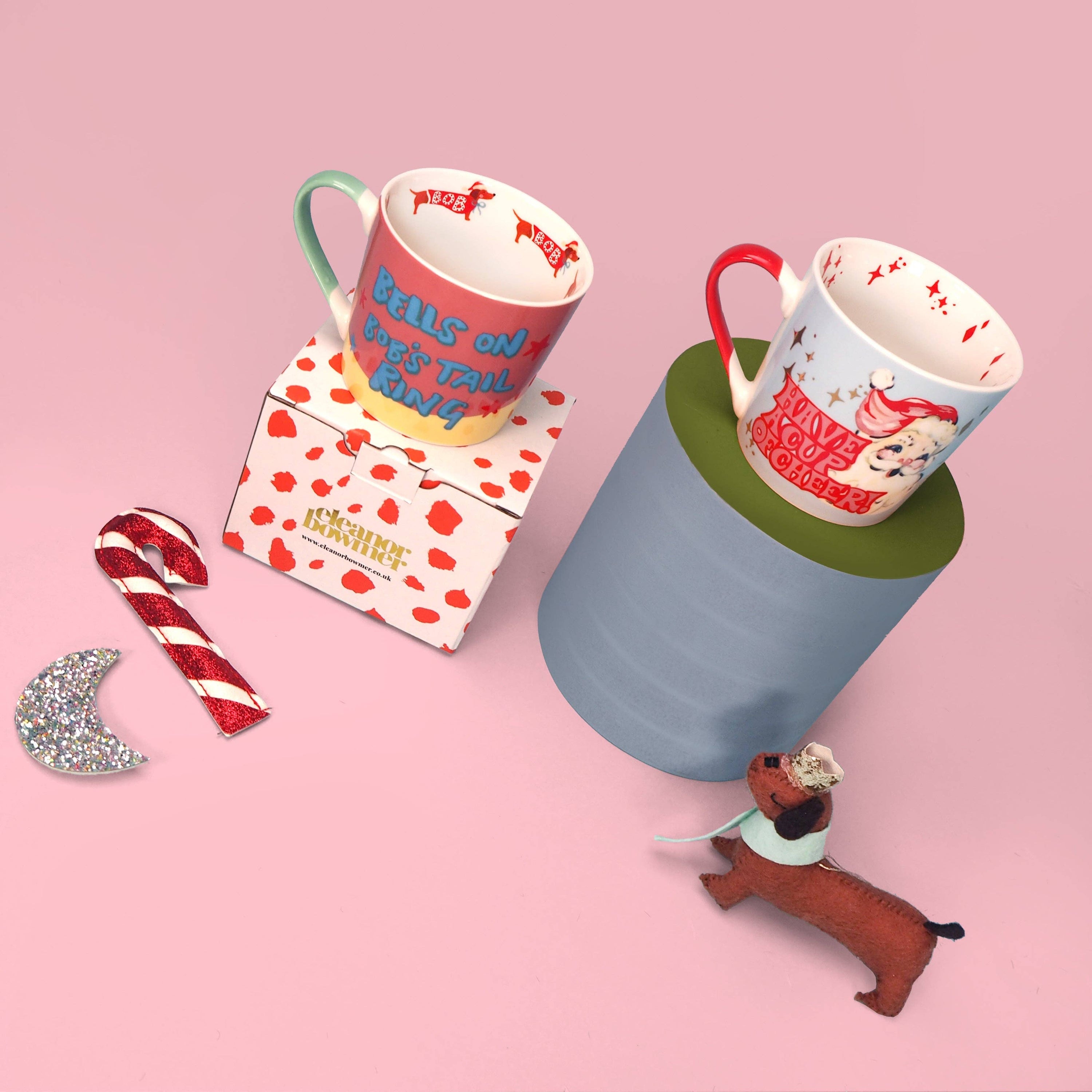 Two mugs with decorative designs on a pink background