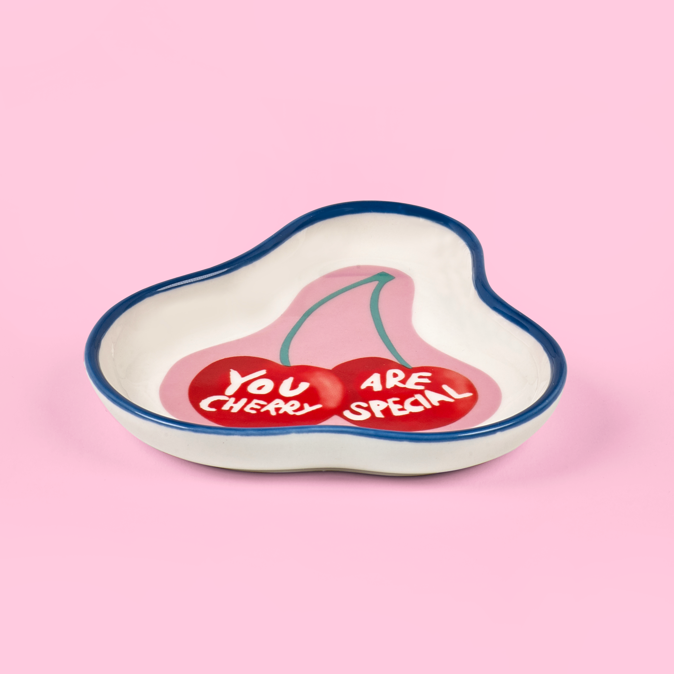 Heart-shaped dish with cherry design and 'You Are Cheeky Special' text on a pink background