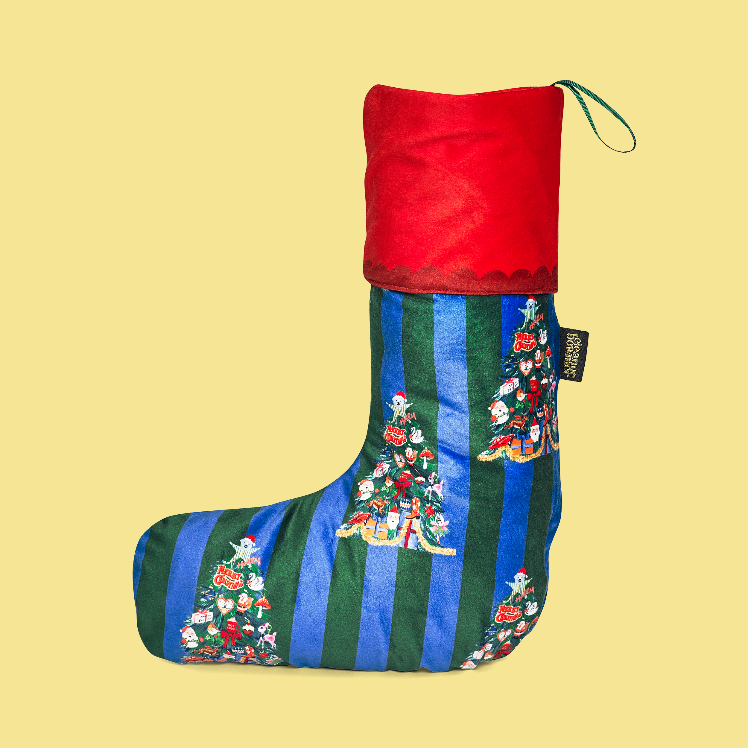 Decorative Christmas stocking with red top and green and blue striped pattern on a yellow background