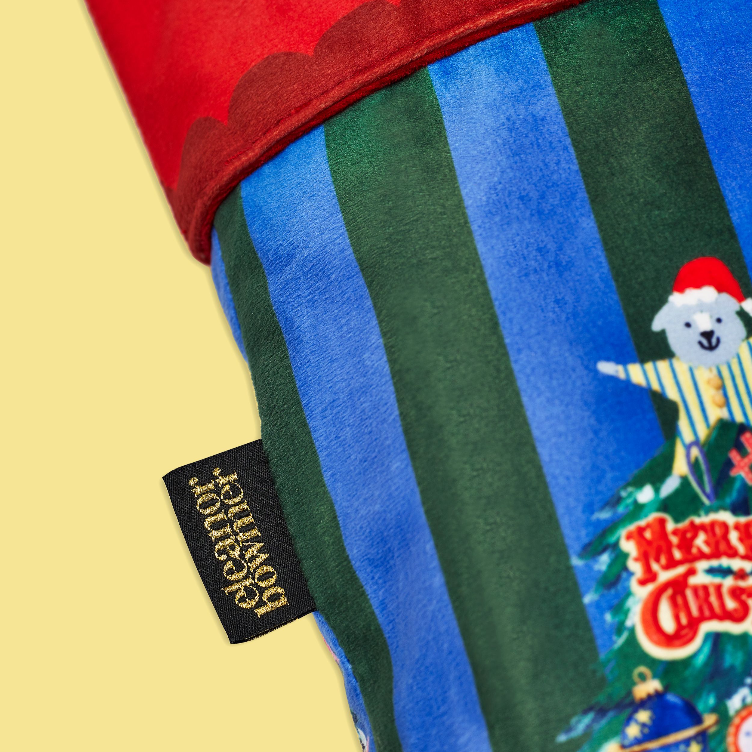 Close-up of a colorful striped fabric with a Christmas-themed design and a visible brand label.