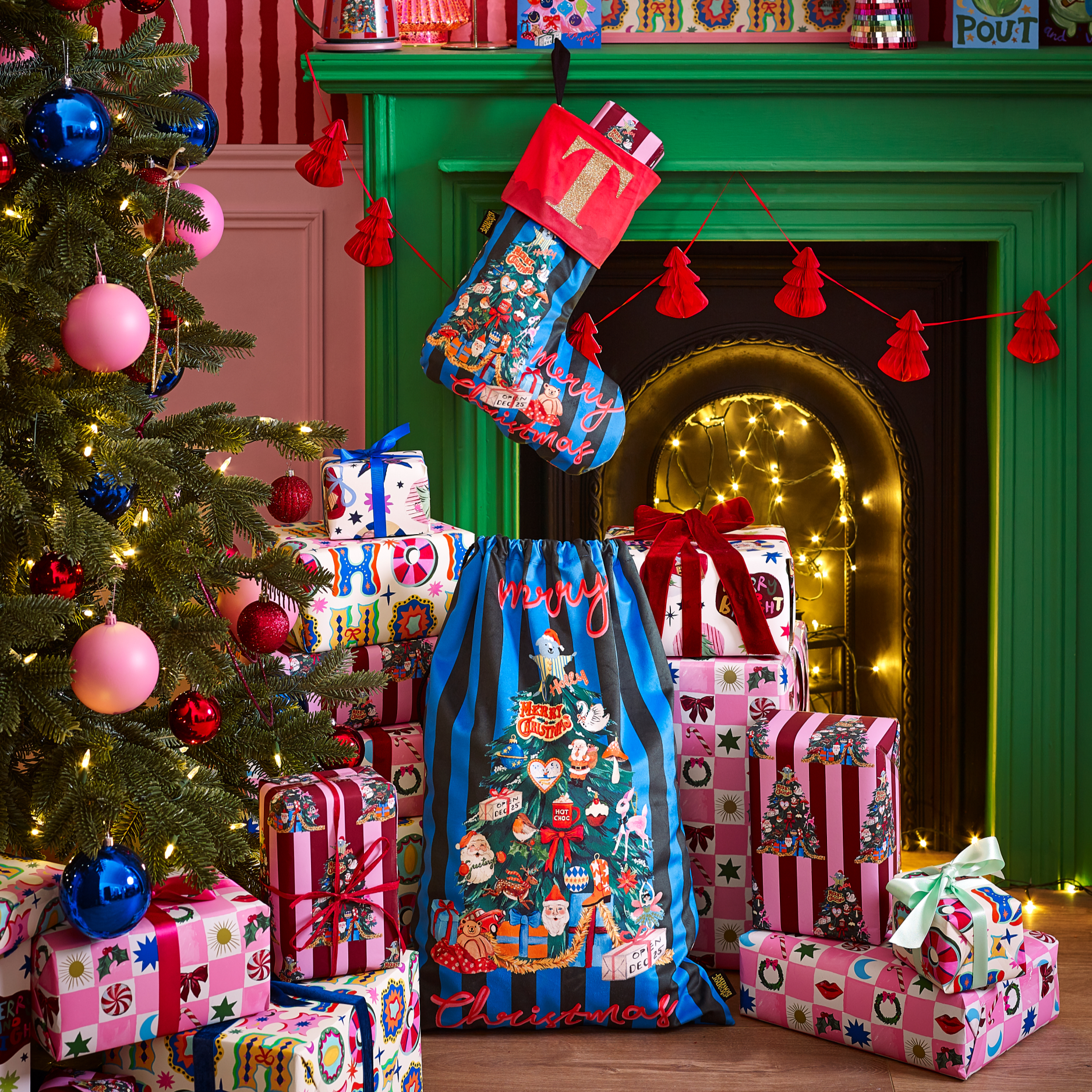 Decorative Christmas scene with a tree, presents, and stockings in a room with a green fireplace.