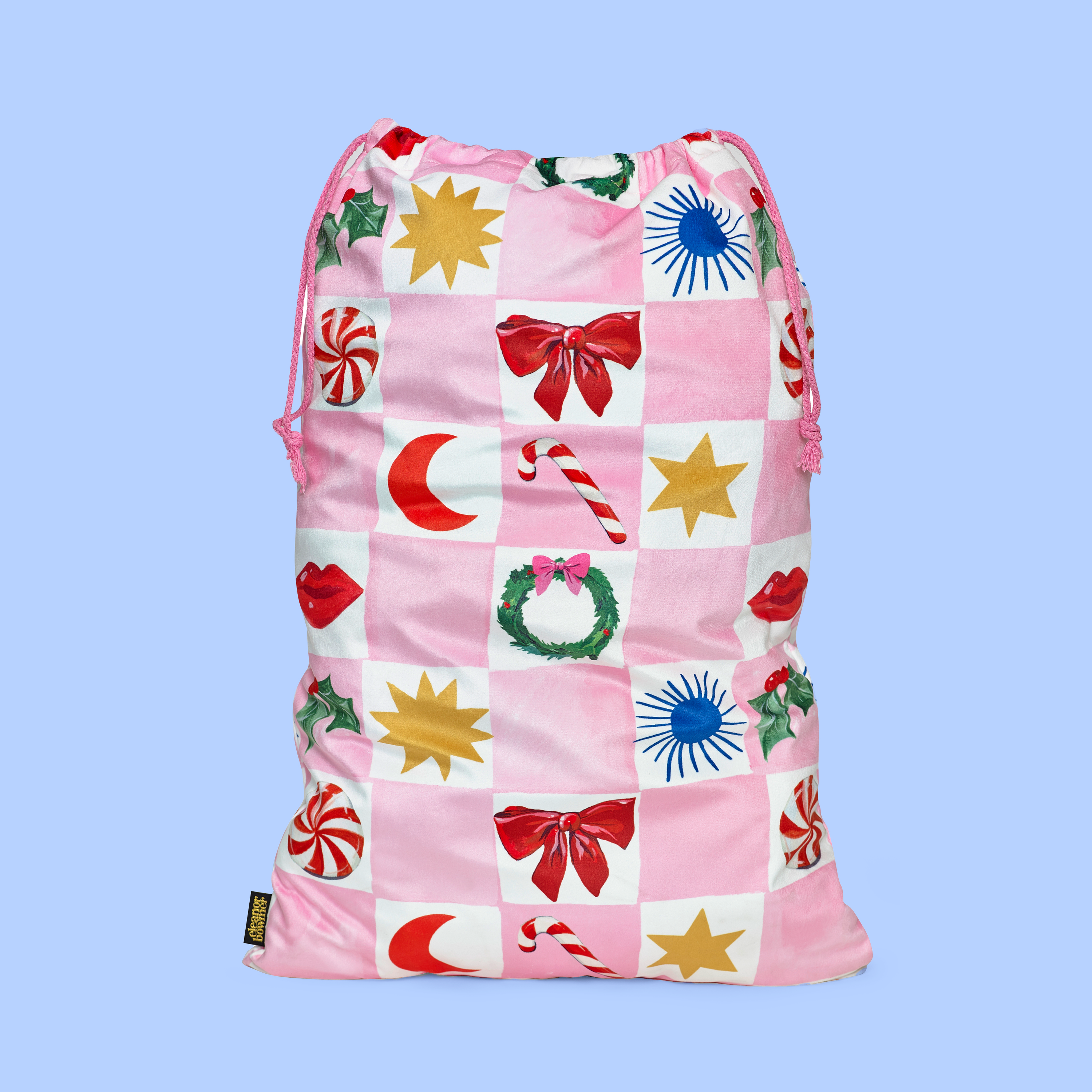 Pink drawstring christmas gift sack with colourful patterns on a light blue background