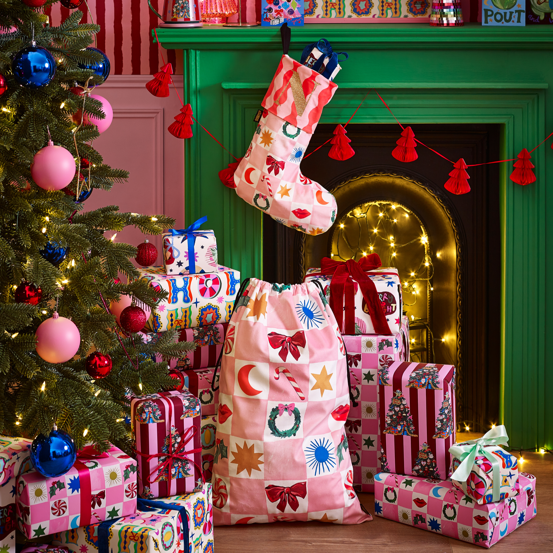 Colourful Christmas presents under a decorated tree with a green fireplace.