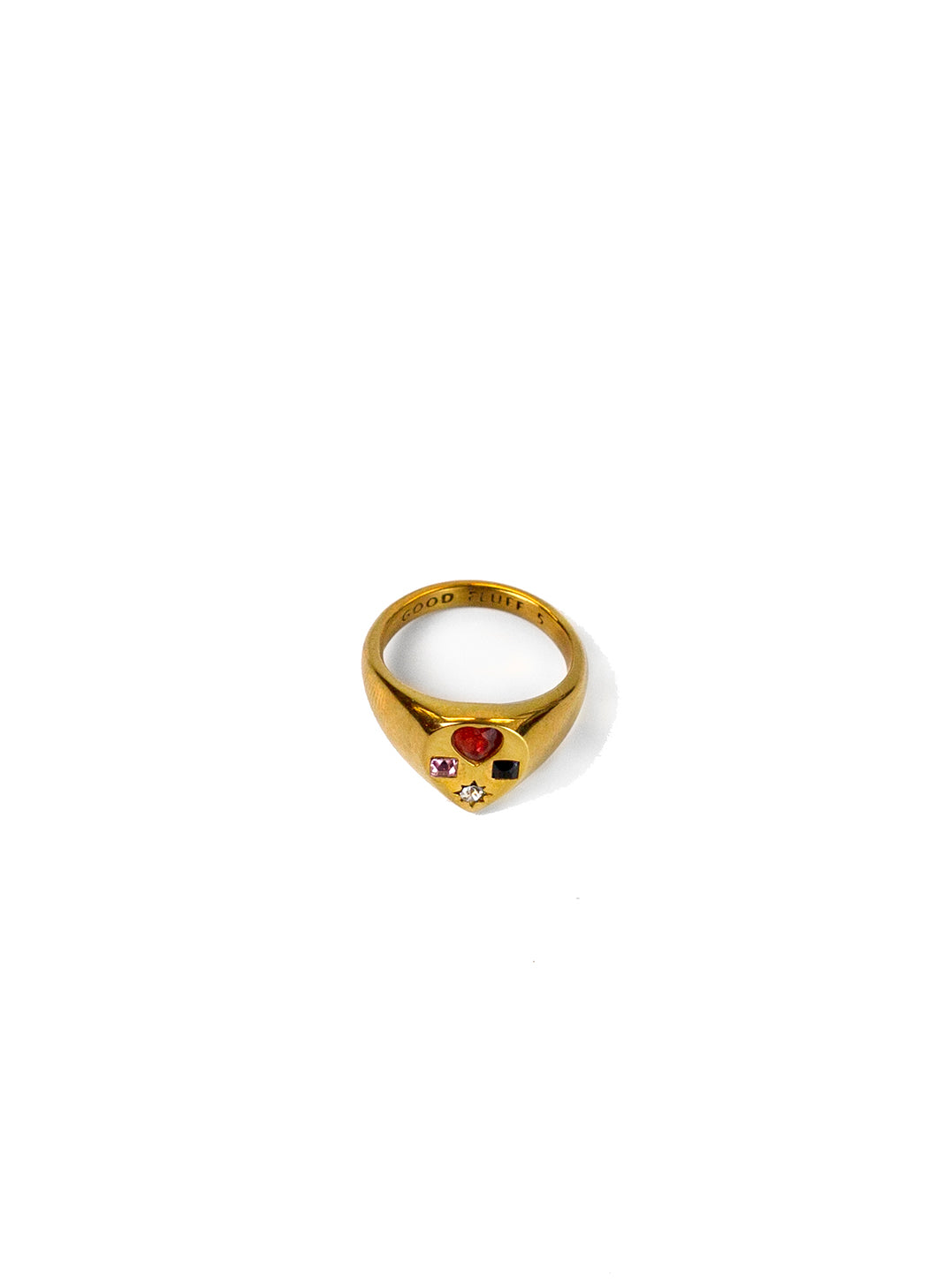 A gold signet ring with a teardrop shape face featuring a small red heart-shaped stone, a tiny clear rhinestone, and a small black heart-shaped stone, set against a plain white background.