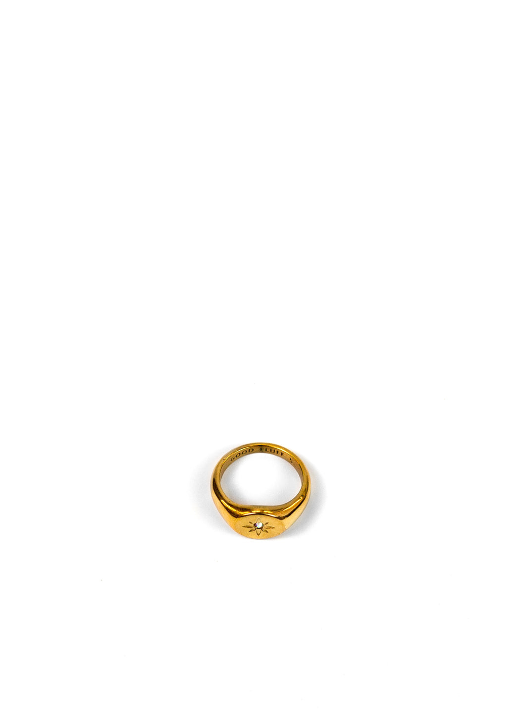 A gold signet ring with  a star engraving, shown on a plain white background.