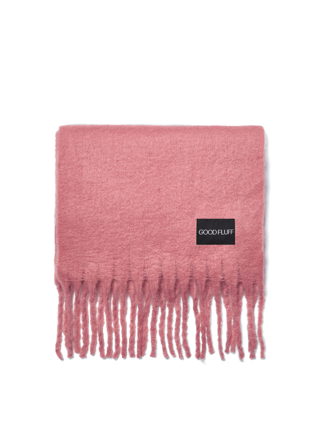 Pink blanket with fringes and a visible brand label on a white background