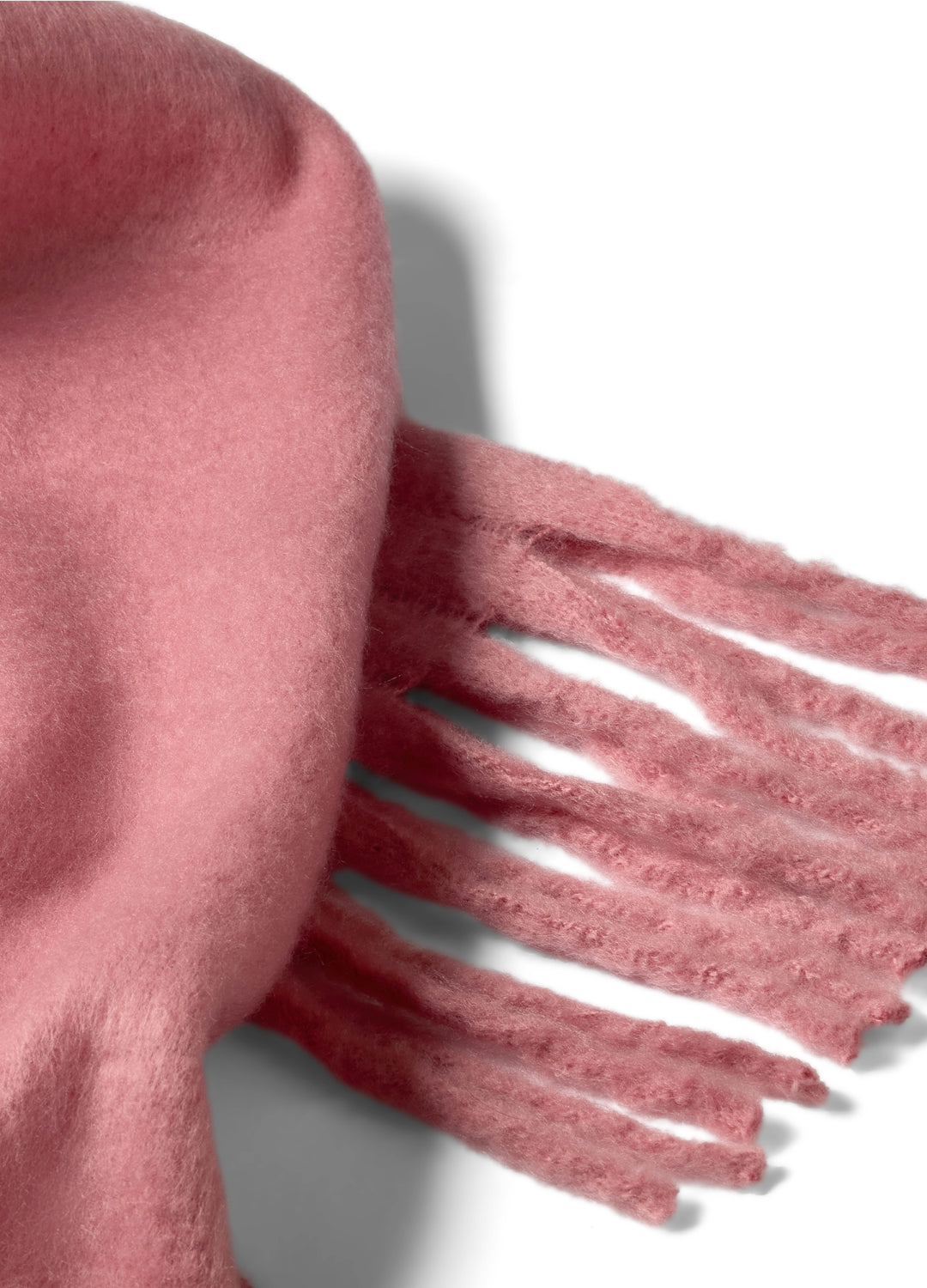 Close-up of a pink scarf with fringes on a light background
