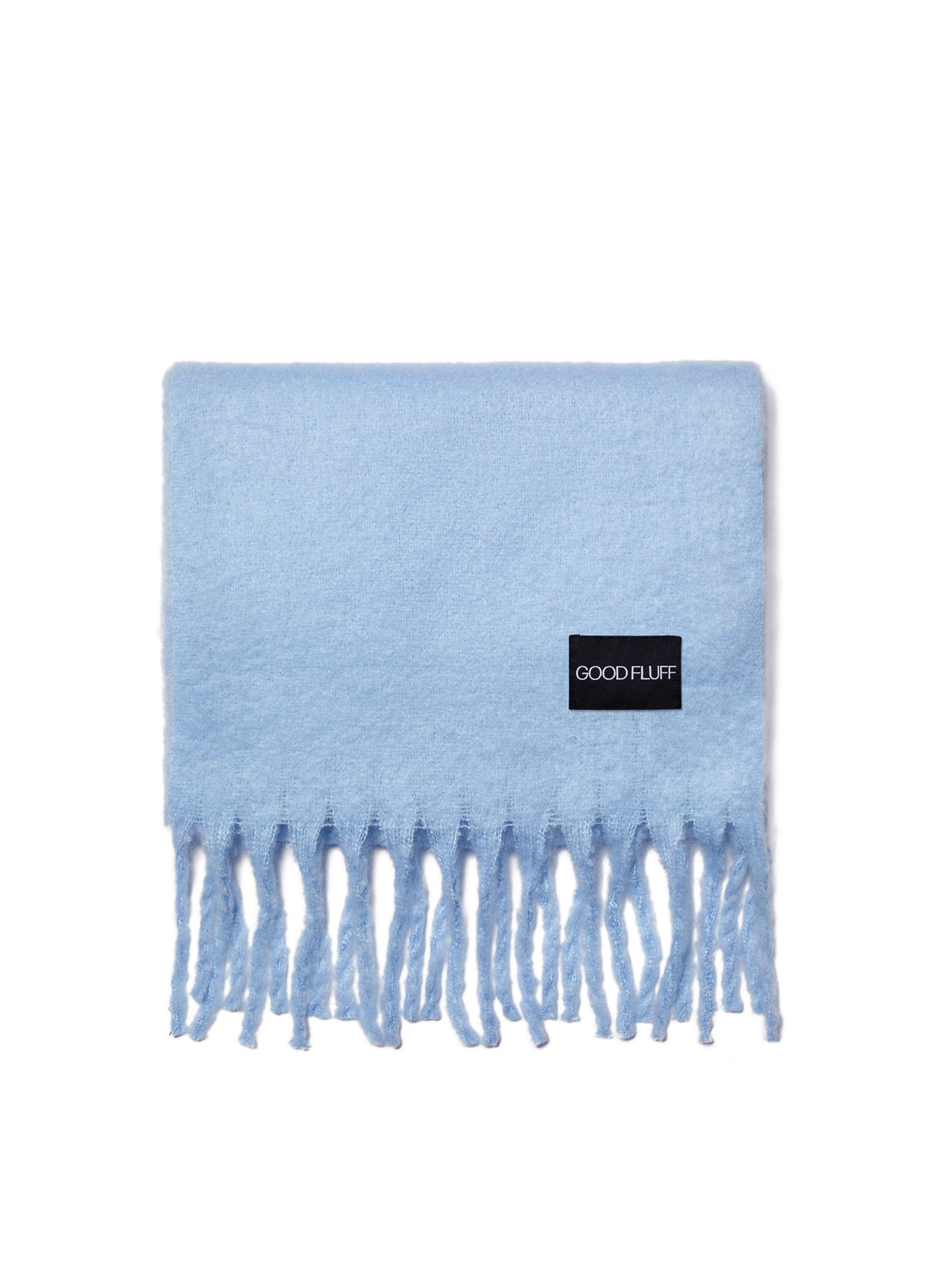 Light blue blanket with fringes and a black label on a white background