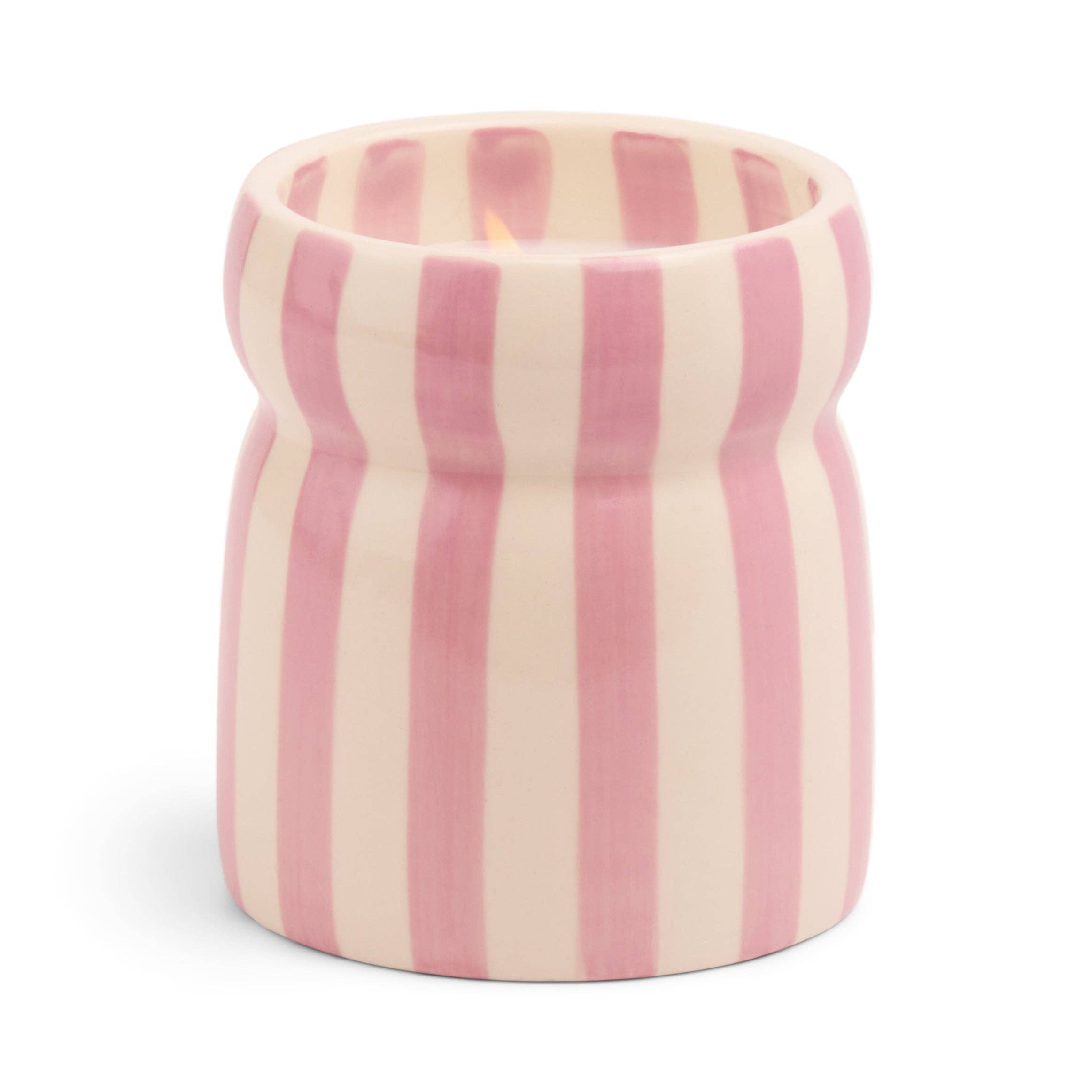 Pink and white striped ceramic candle on a white backdrop