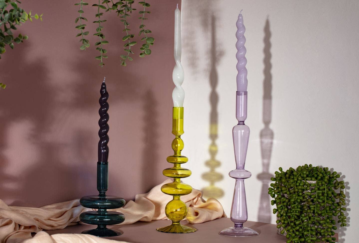 Three colorful candlesticks on a surface with a soft background