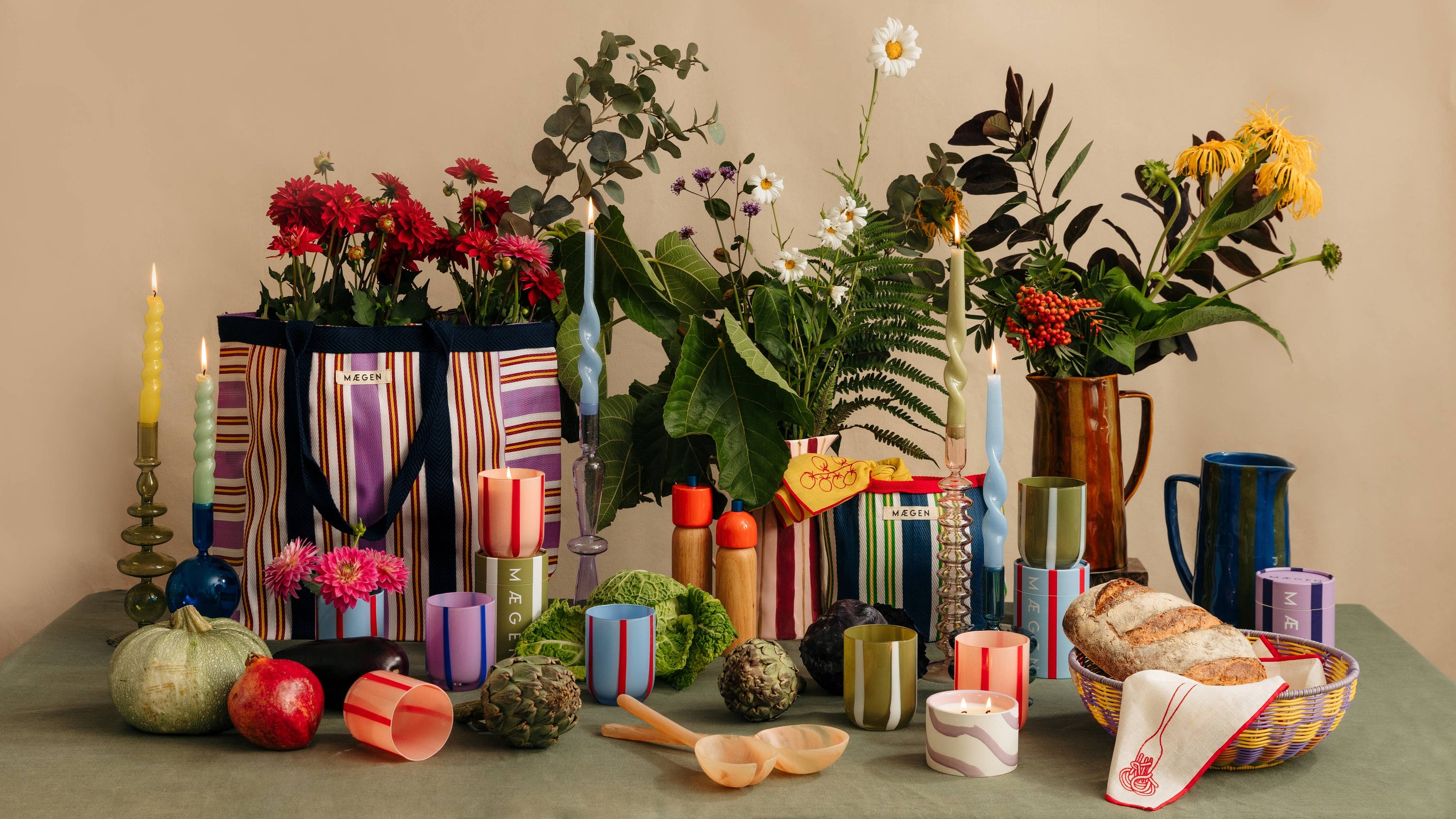 Decorative table setting with flowers, candles, and bread on a neutral background
