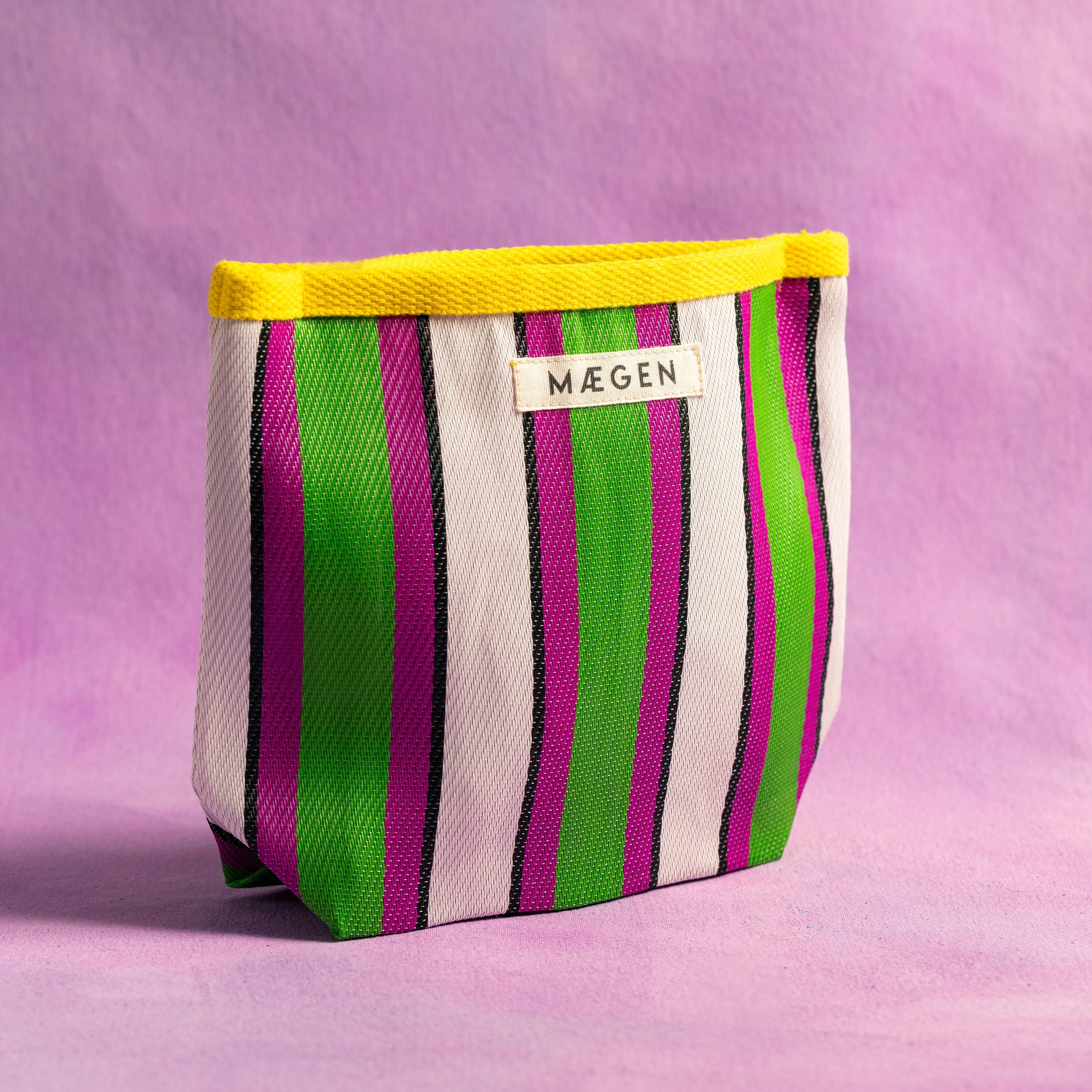 Striped fabric pouch with yellow top on a pink background