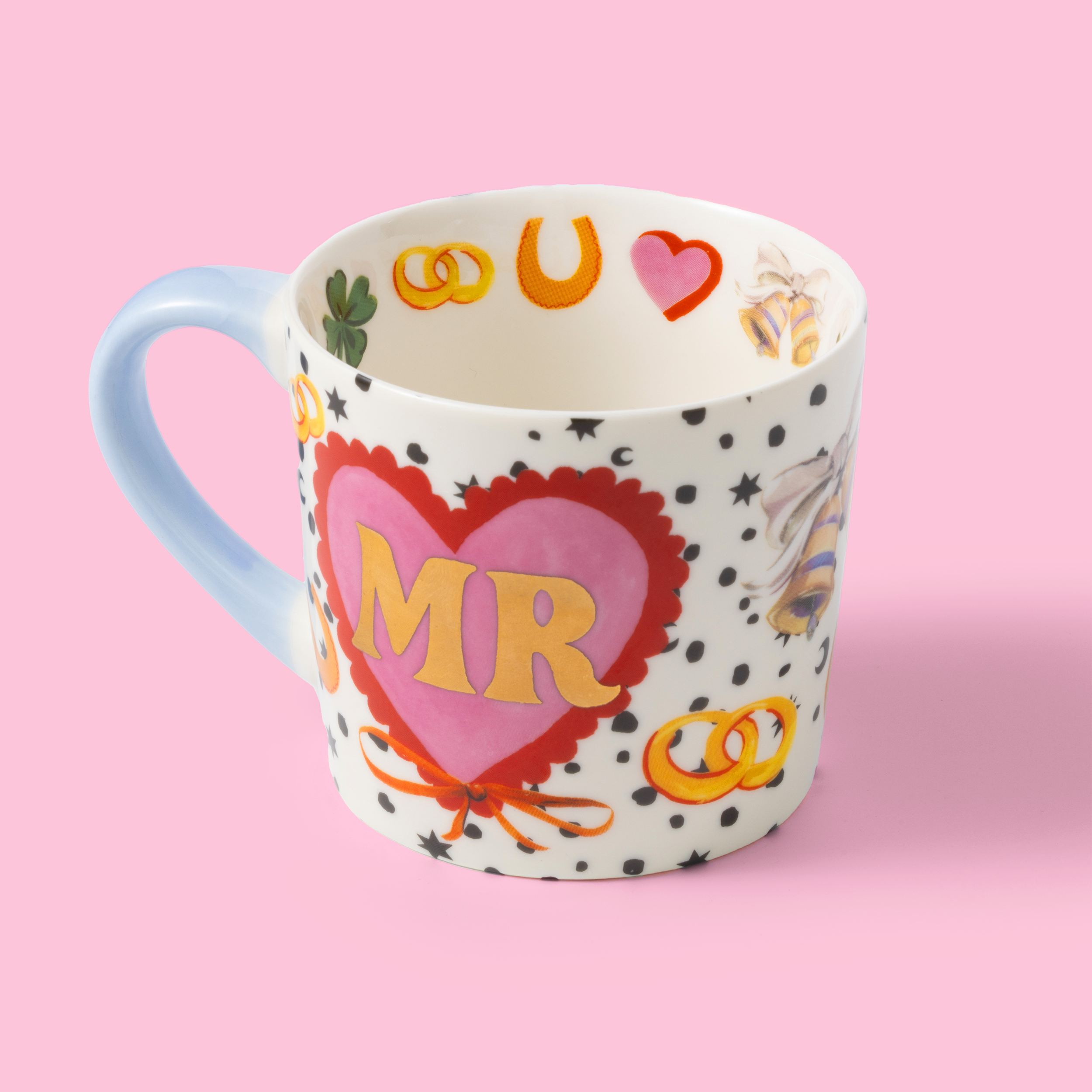 Decorative mug with heart design and 'MR' text on a pink background