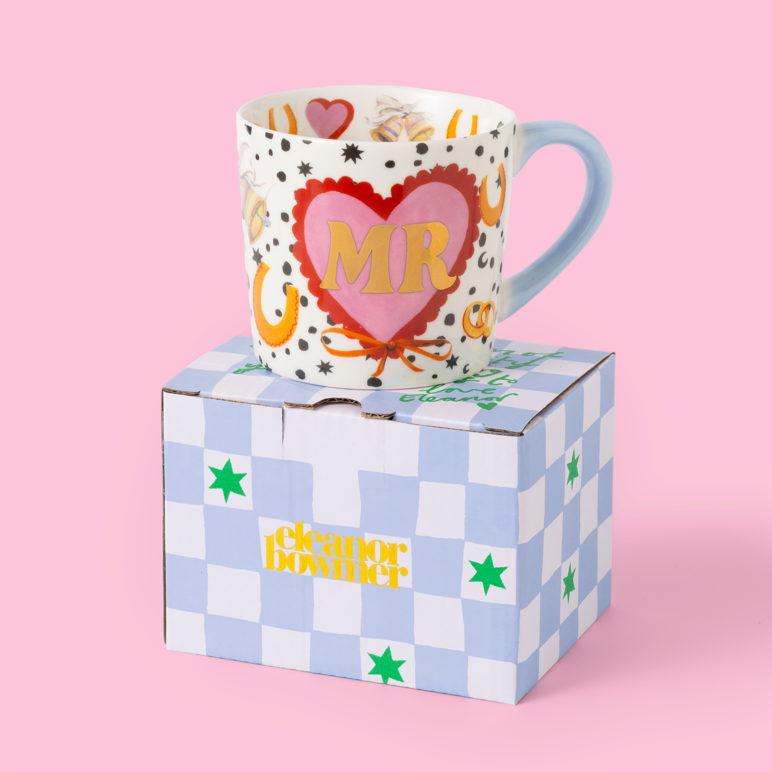 Decorative mug with heart and 'MR' design on a checkered box against a pink background