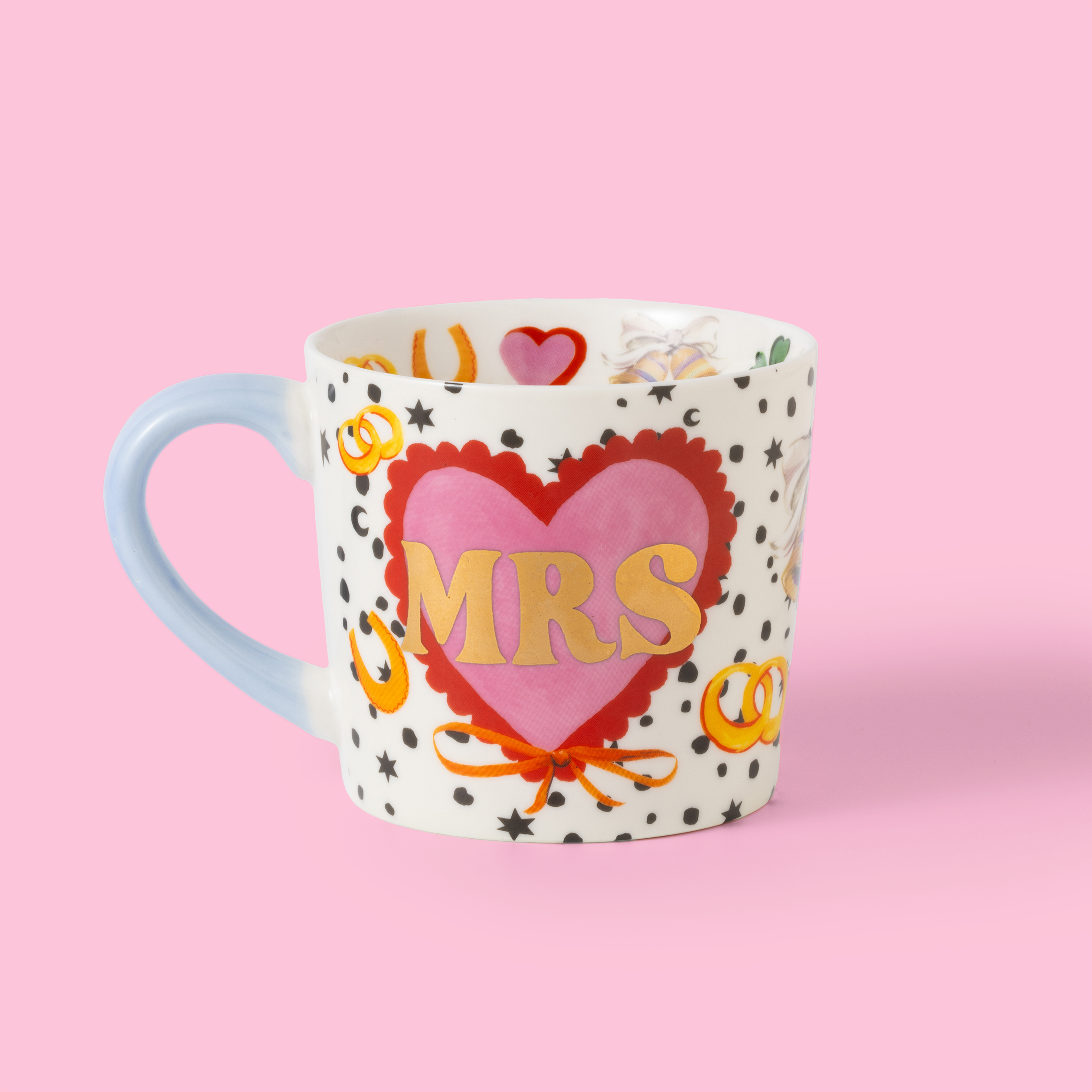 Mug with heart design and 'MRS' text on a pink background