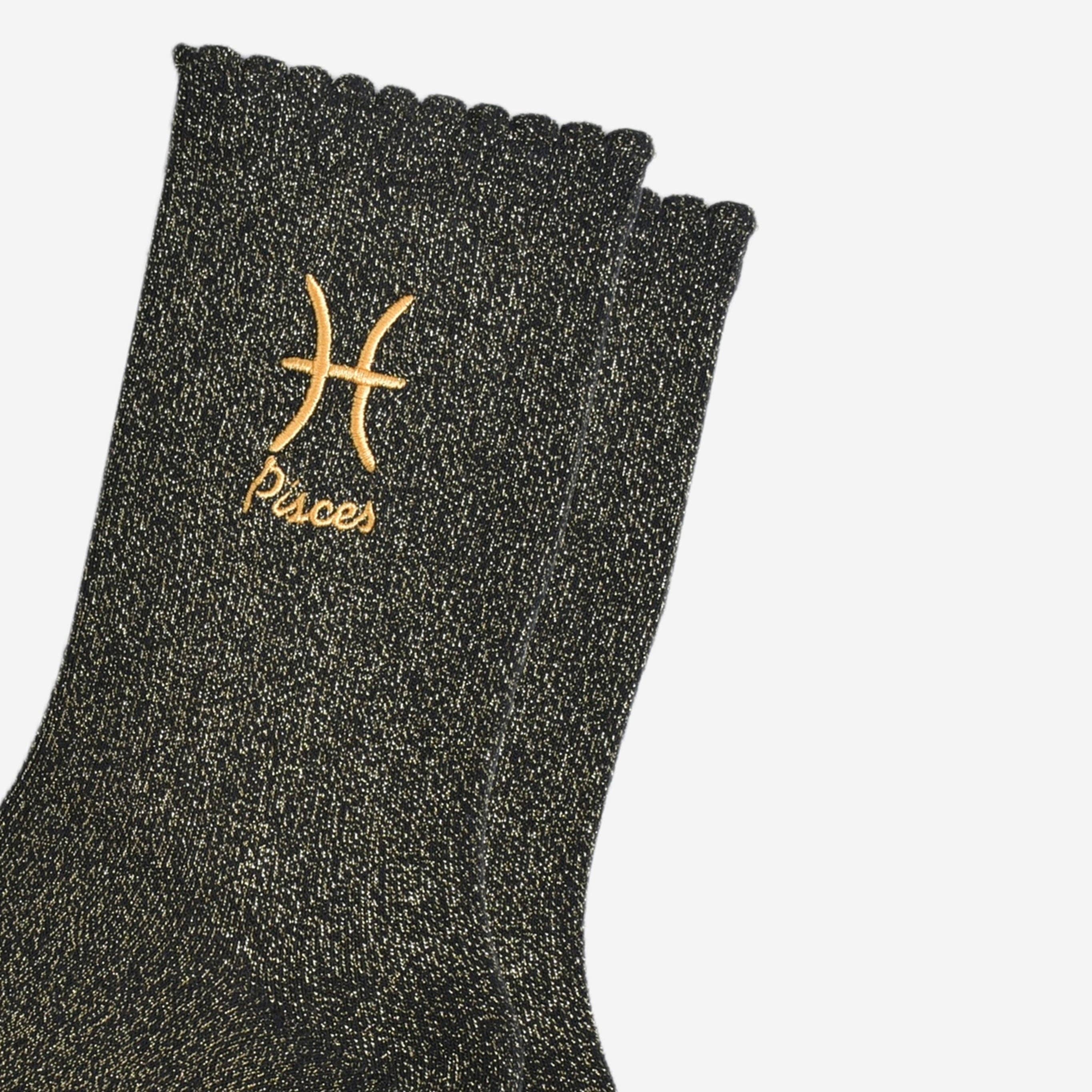 Black glittery sock with gold Pisces symbol and text on a white background