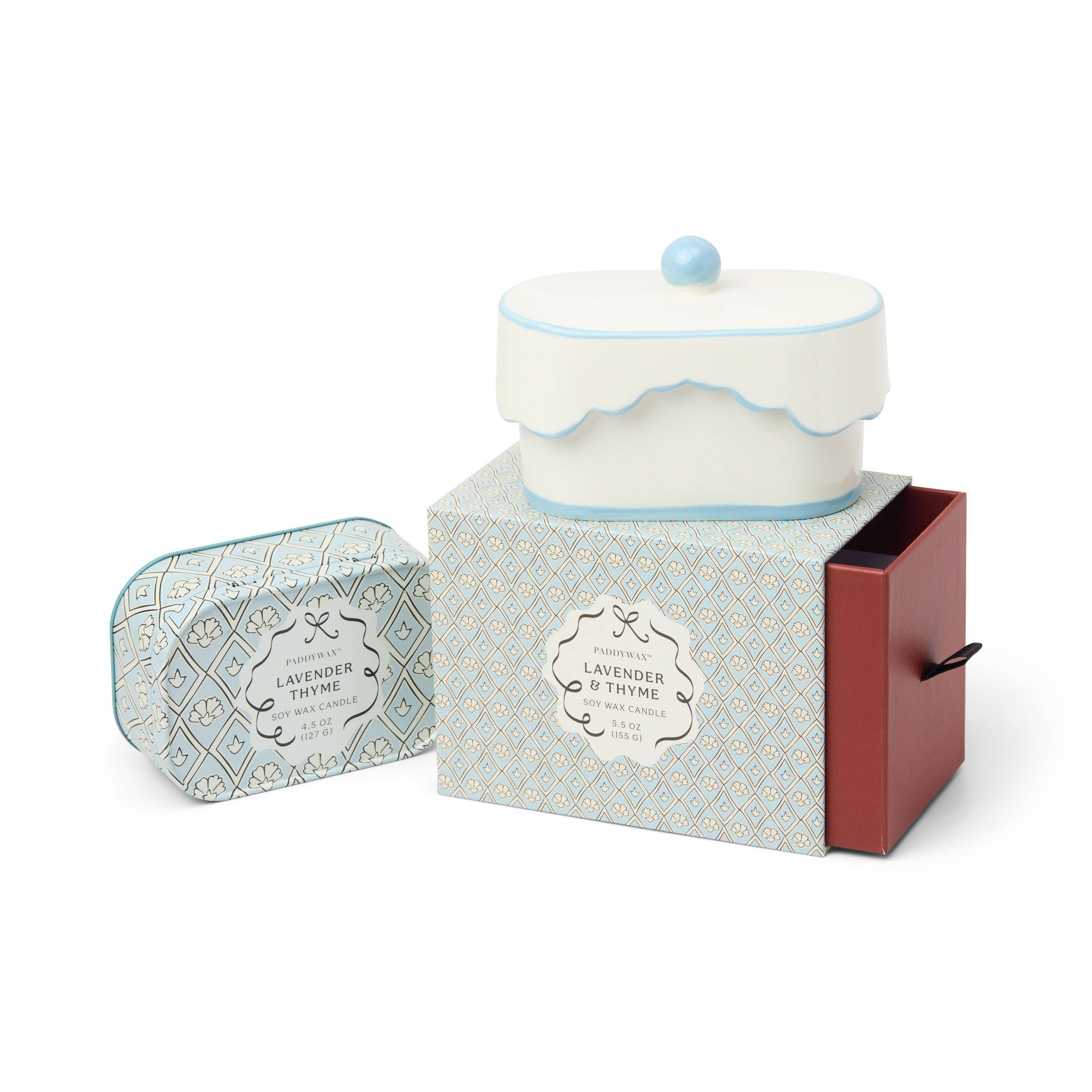 Candle in a decorative box with a small container labeled 'Lavender & Thyme' on a white background