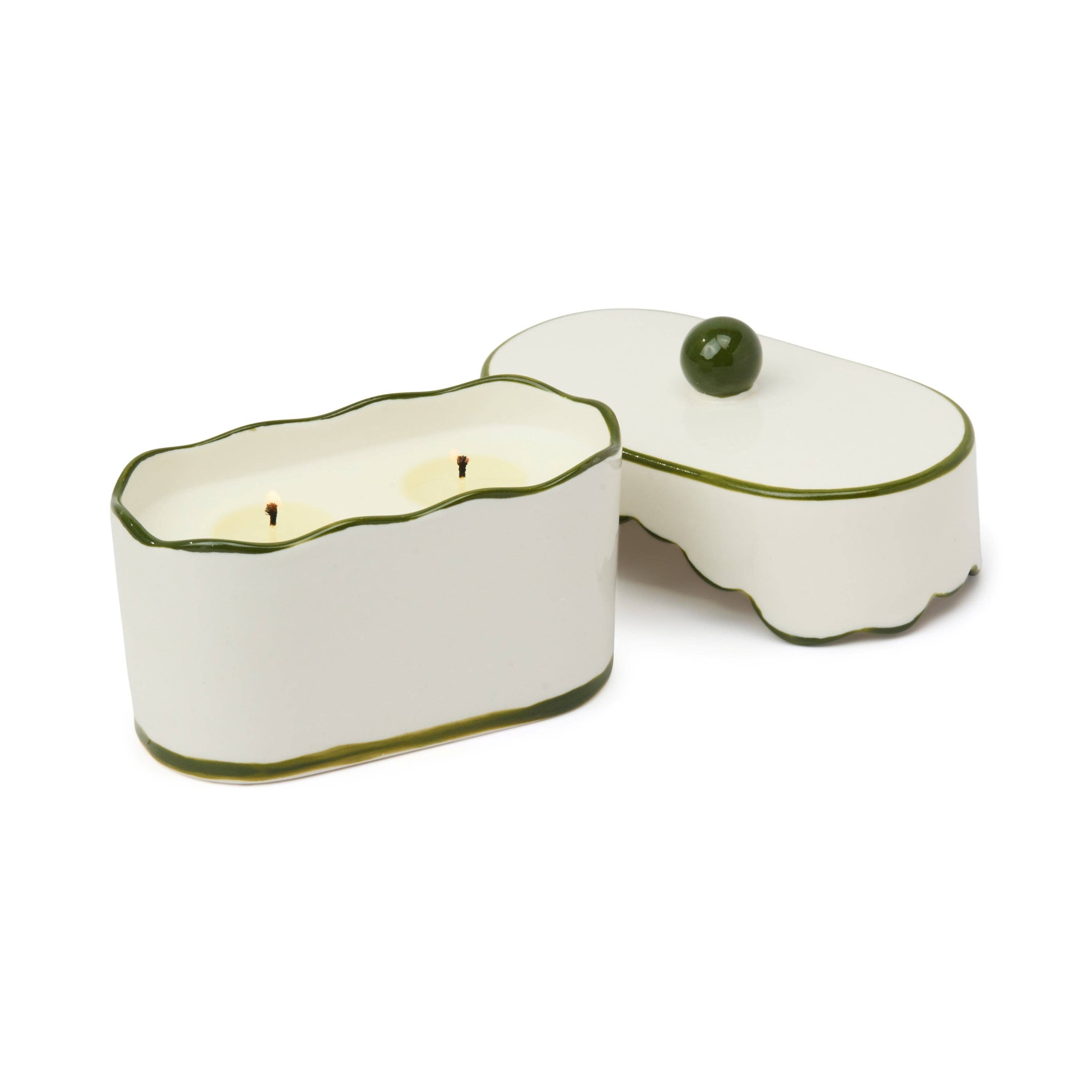 White ceramic candle holder with green rim on a white background