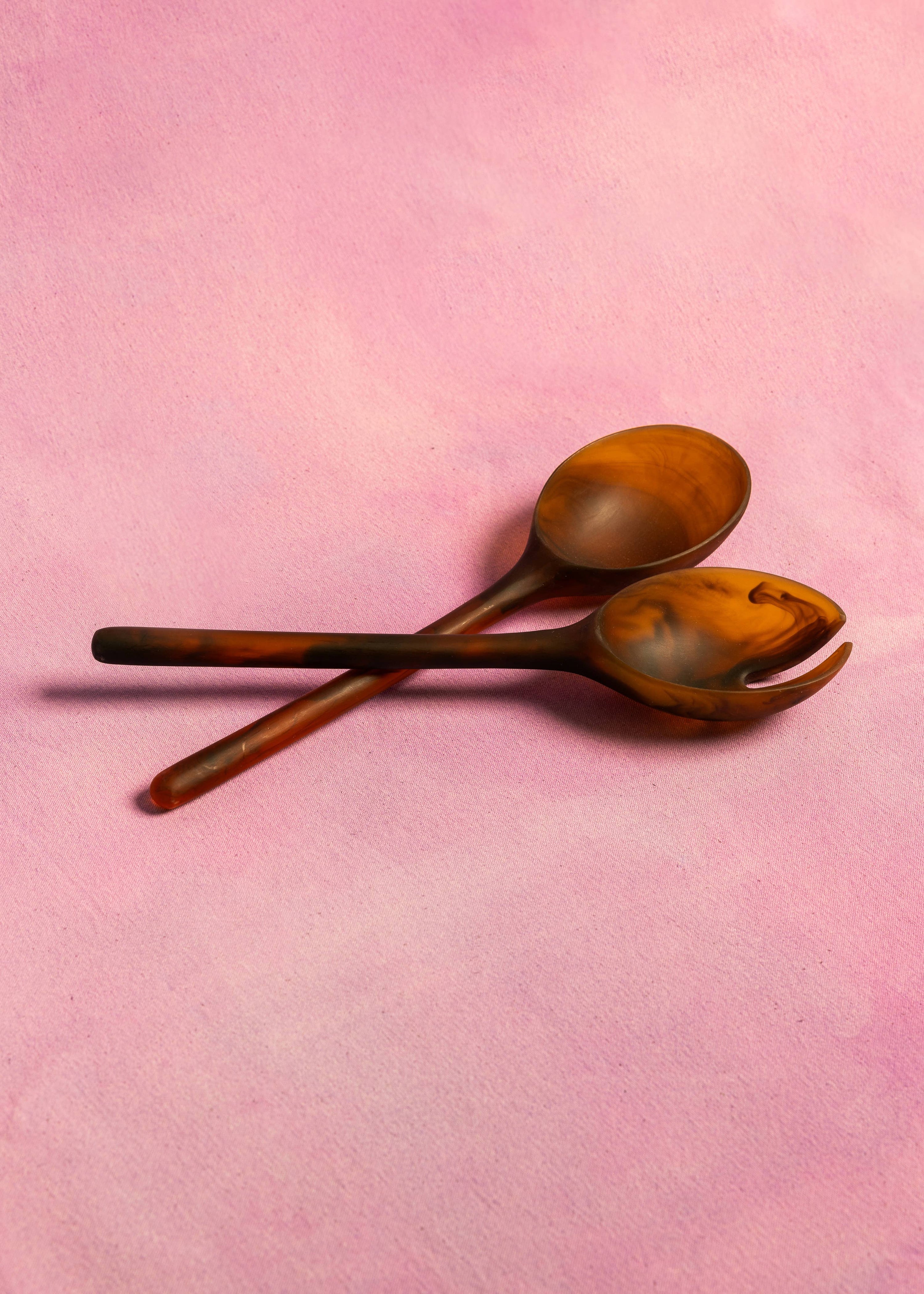 Two wooden spoons on a pink background