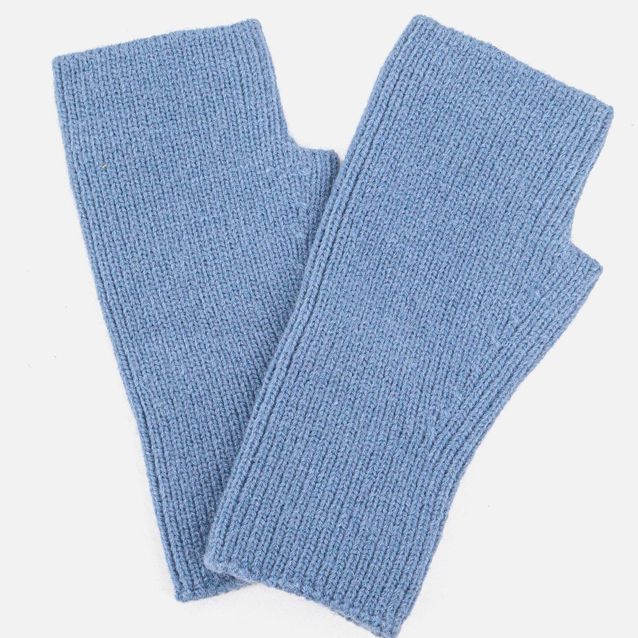 Pair of blue knitted arm warmers on a light gray background