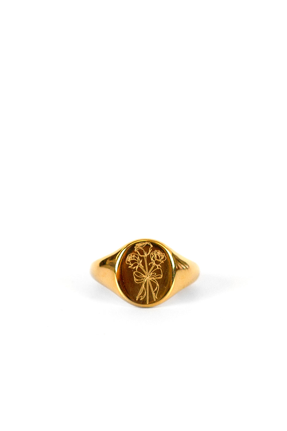 A gold signet ring with an oval face featuring an engraved floral design, displayed on a clean white background.