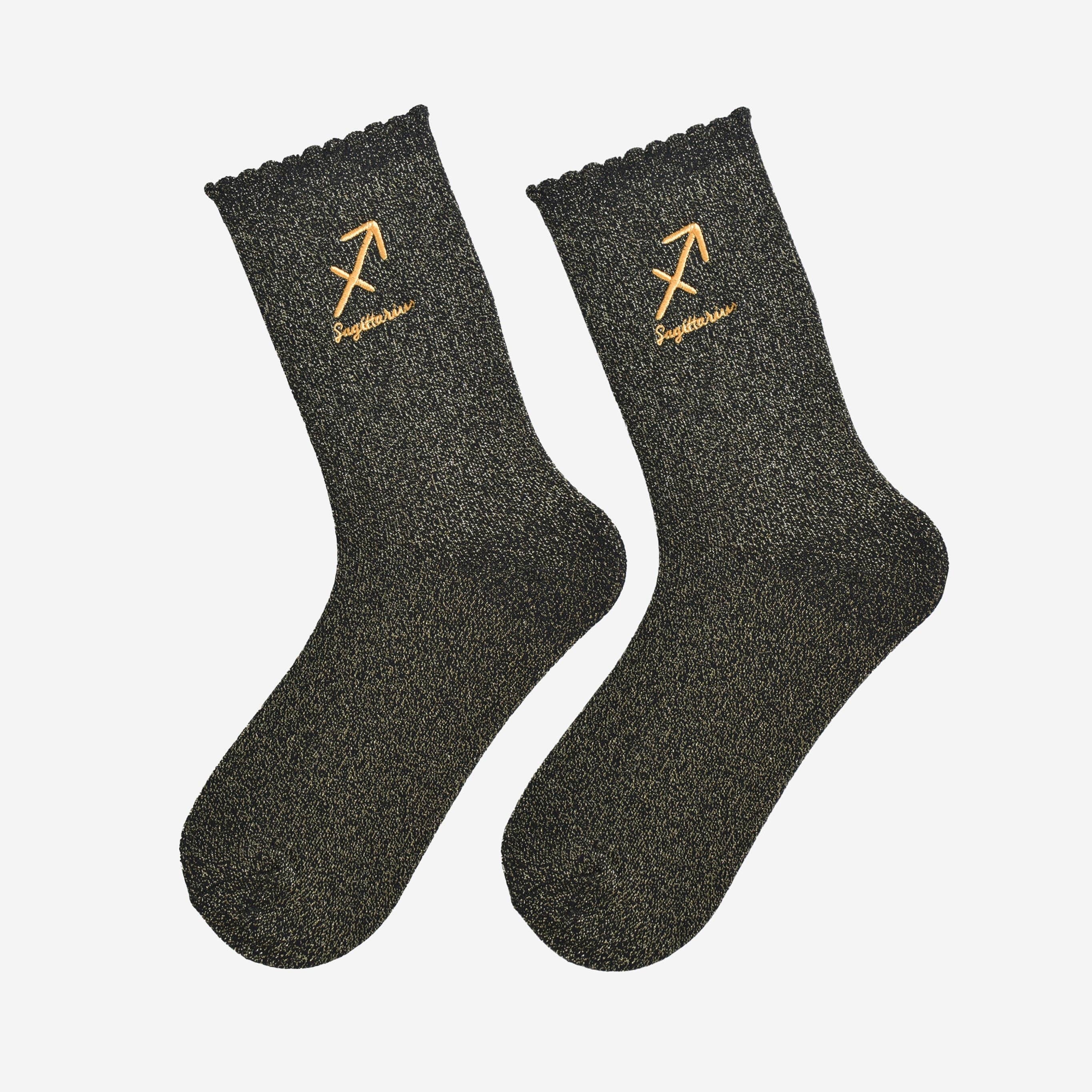 Pair of black socks with gold embroidered designs on a white background
