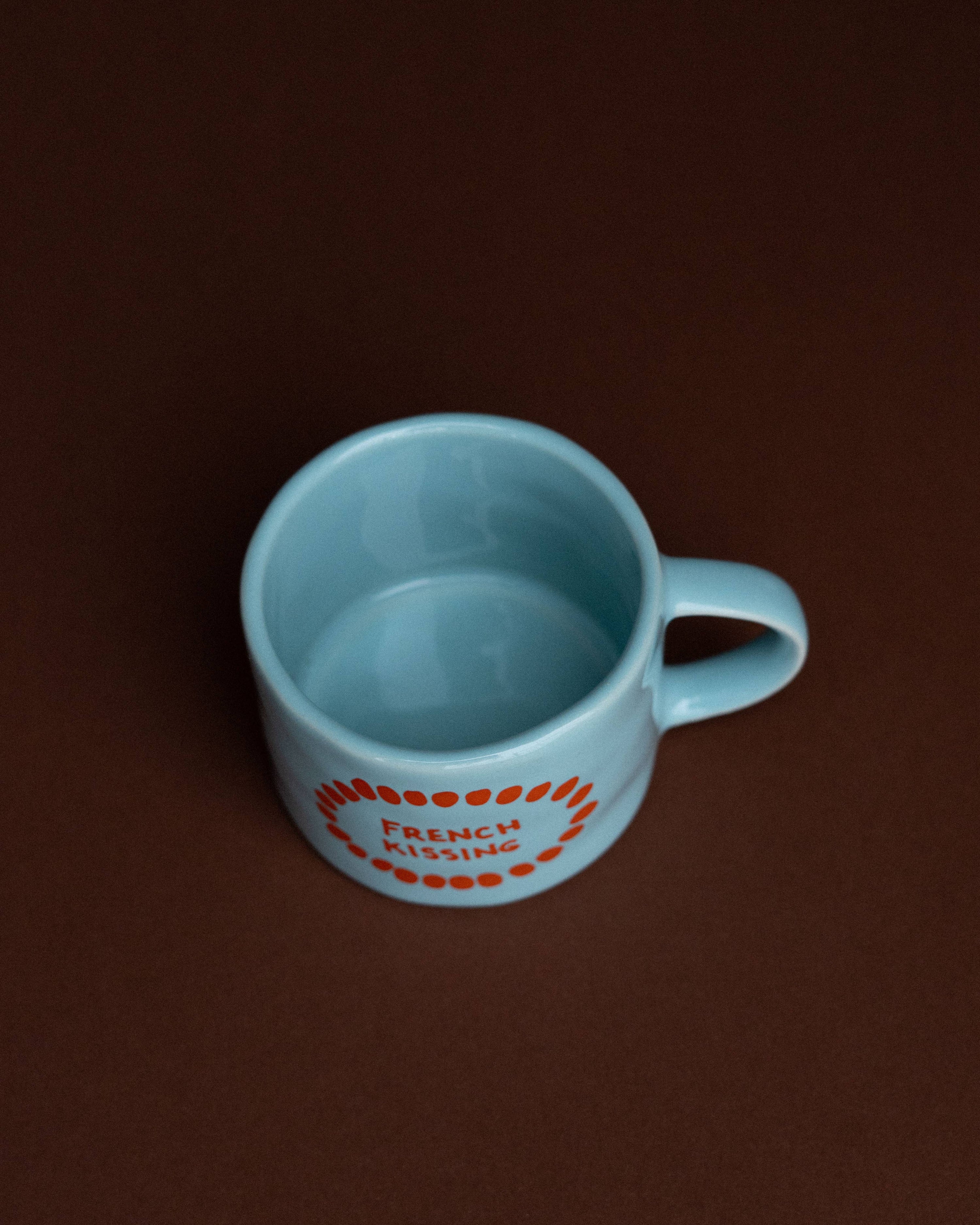 Light blue mug with orange text on a brown background