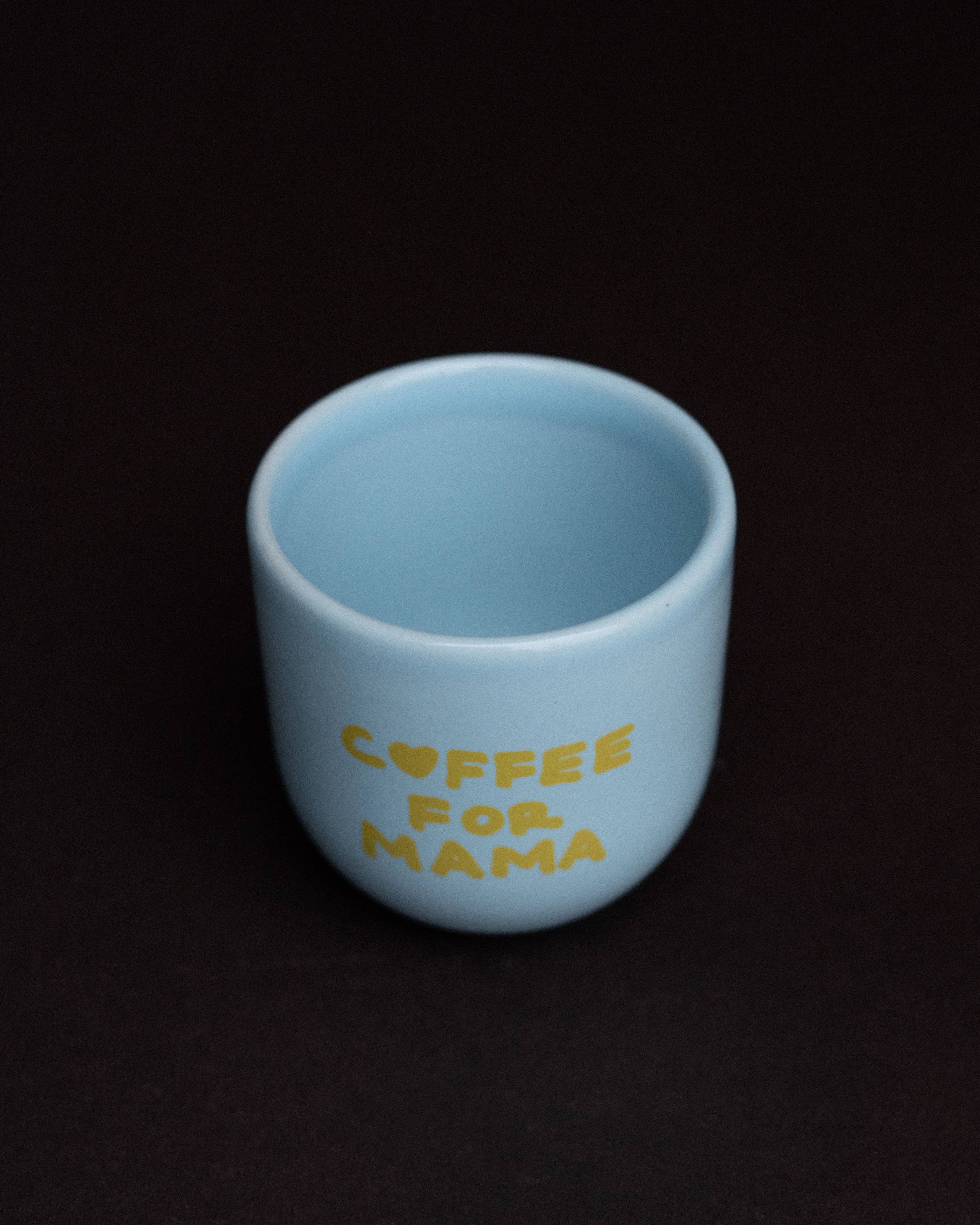 Light blue mug with 'Coffee for Mama' text on a black background