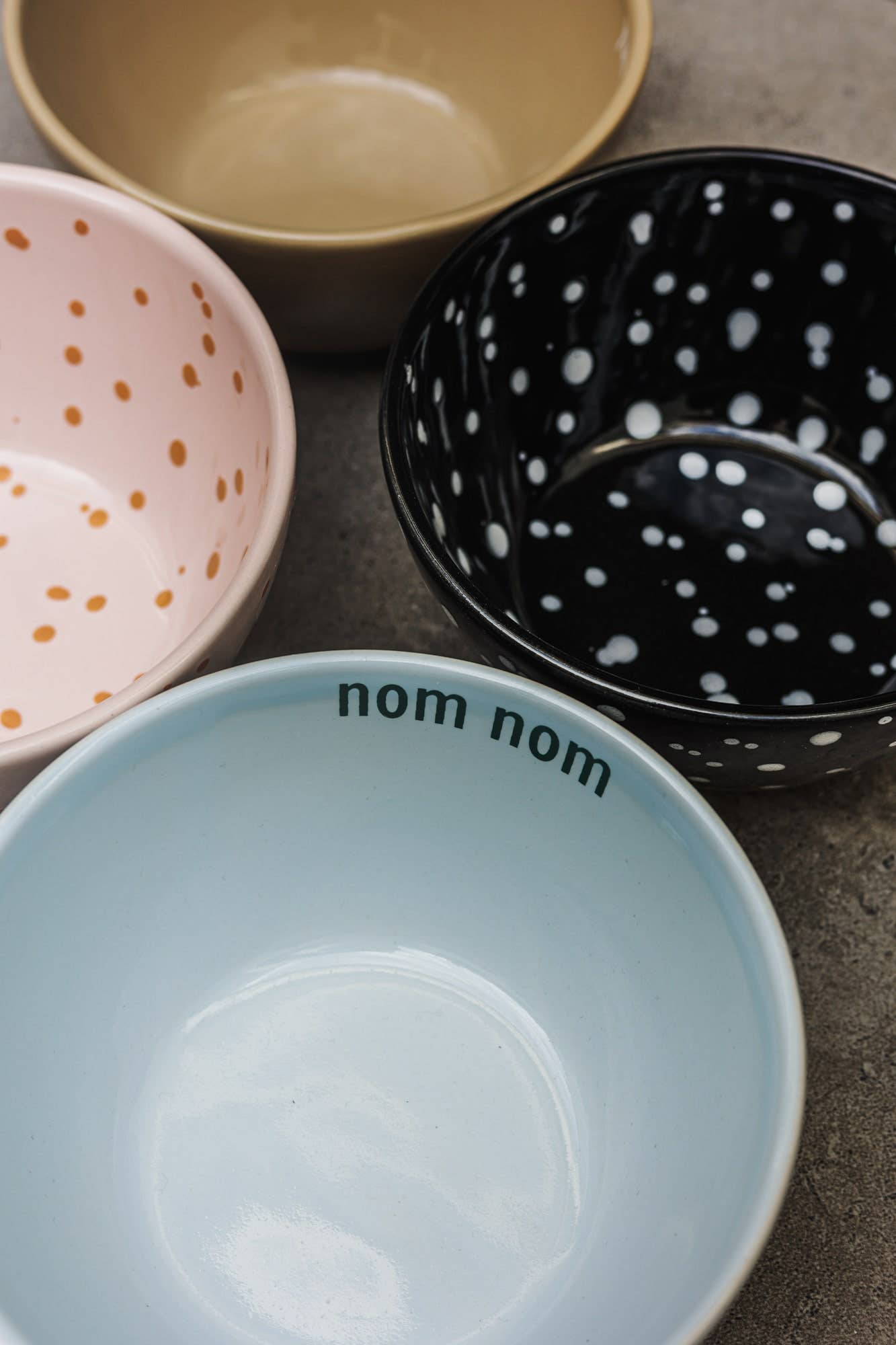 Set of ceramic bowls with different designs on a gray surface