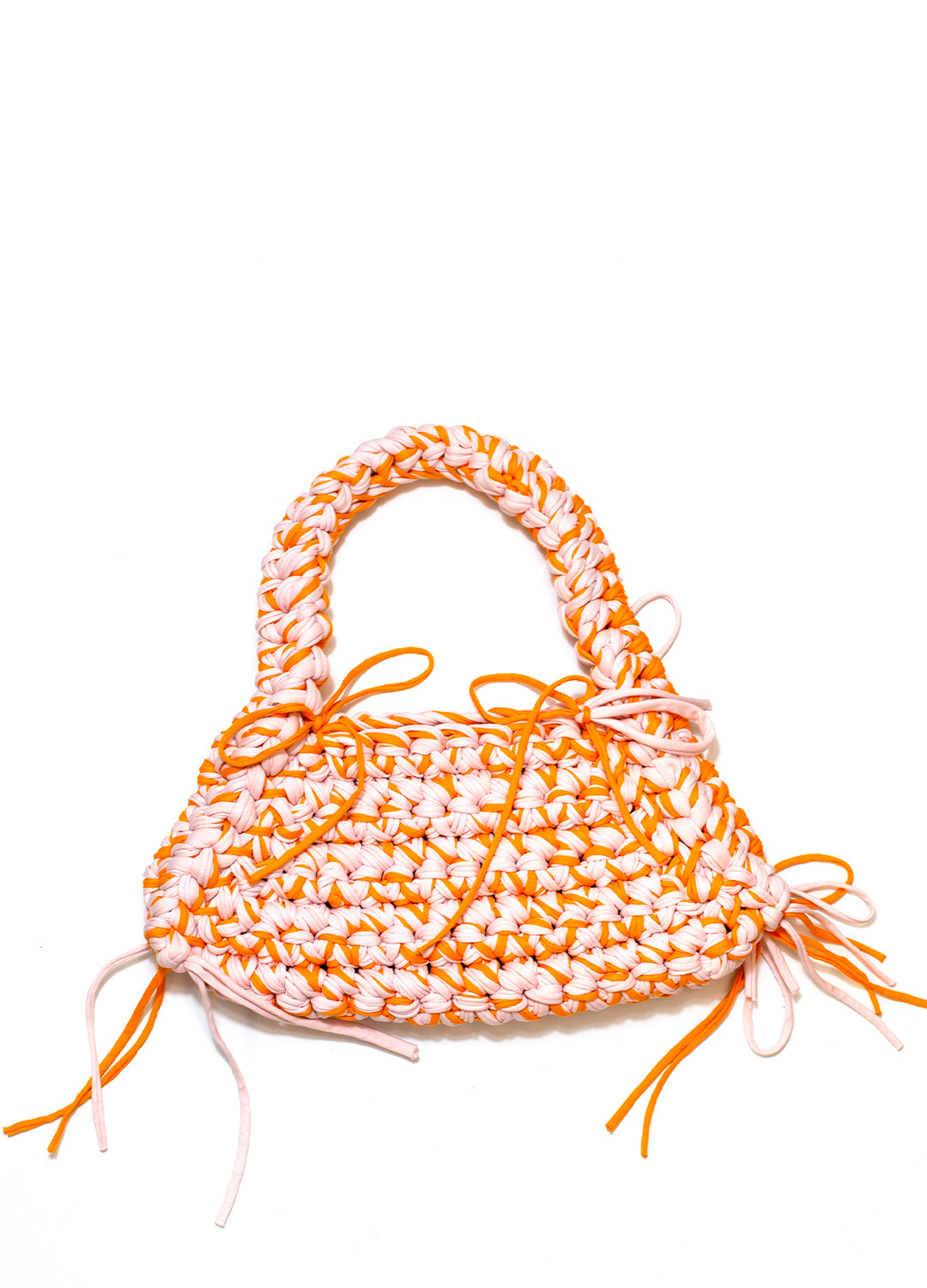 A crochet weaved orange & pink shoulder bag against a whitebackdrop