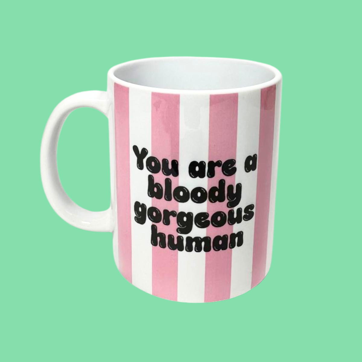 Mug with pink and white stripes and text on a green background