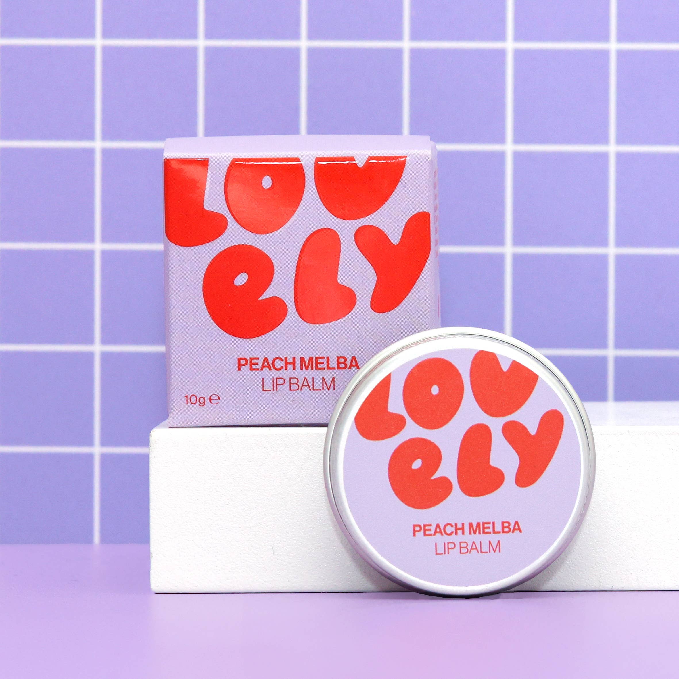 Lovelily Peach Melba lip balm with packaging on a purple grid background