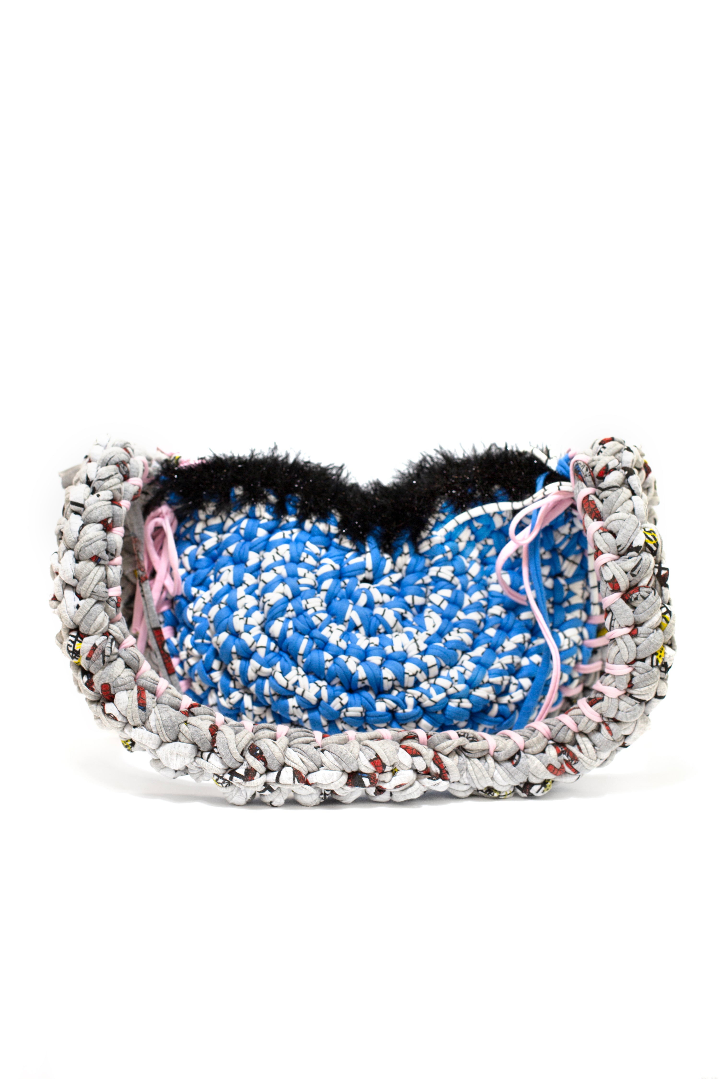 crochet weaved cross body bag with blue center and multicoloured edges on a white background