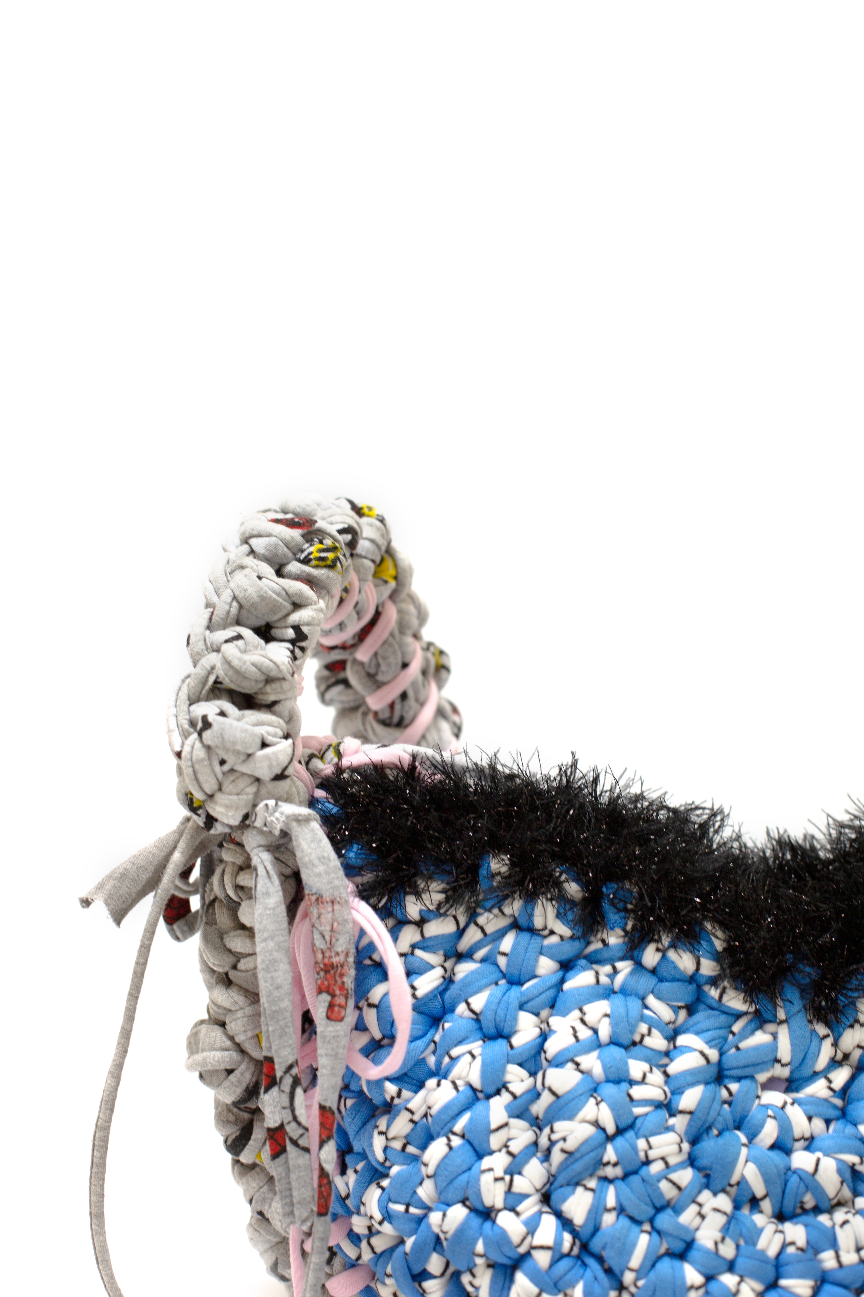 Close-up of a textured bag with a braided handle on a white background