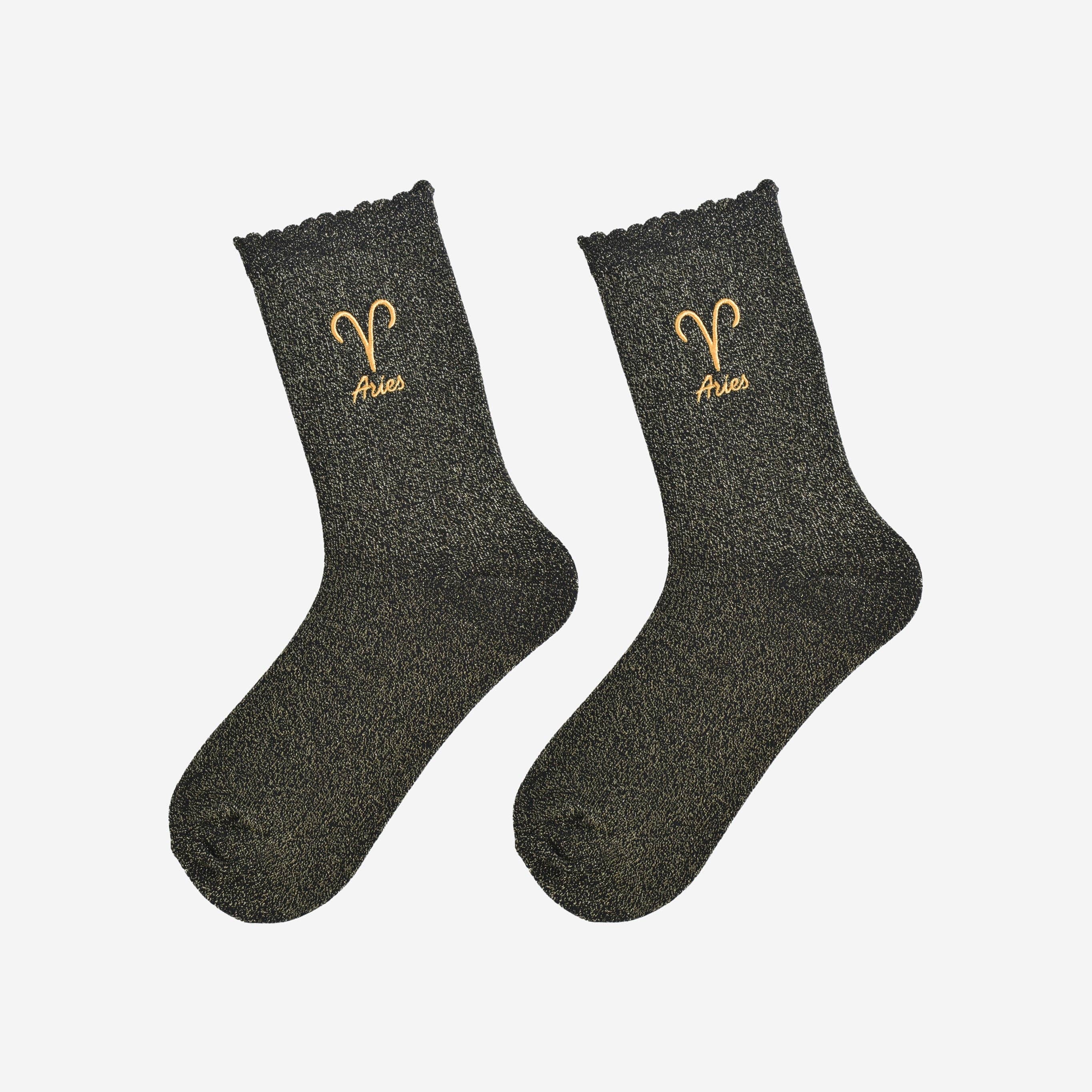 Pair of black socks with Aries symbol and text on a light gray background