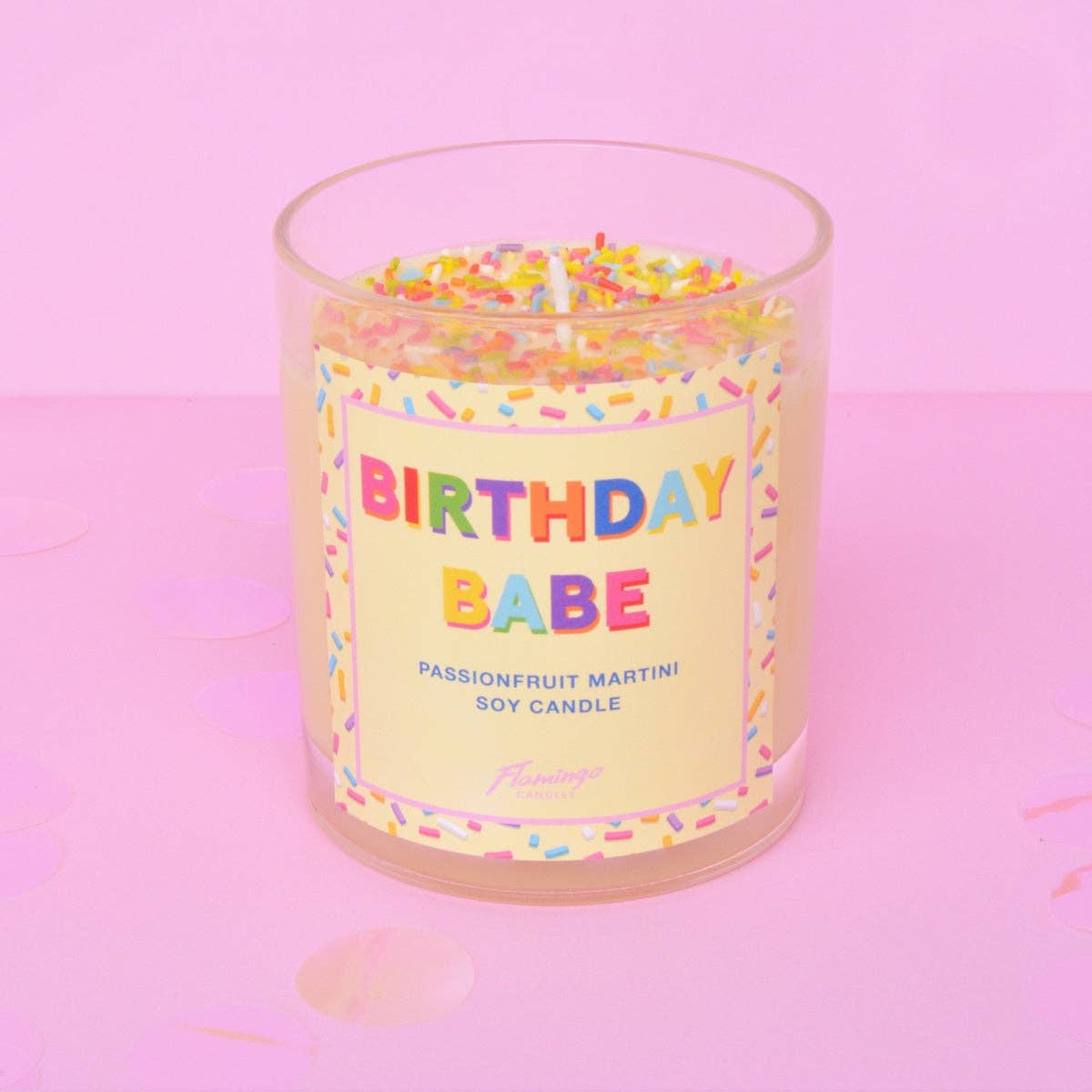 Candle labeled 'Birthday Babe' with colorful sprinkles on a pink background