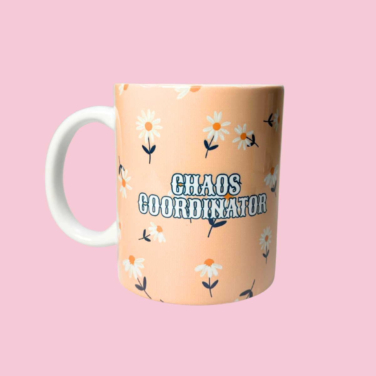 Mug with 'Chaos Coordinator' text and floral design on a pink background