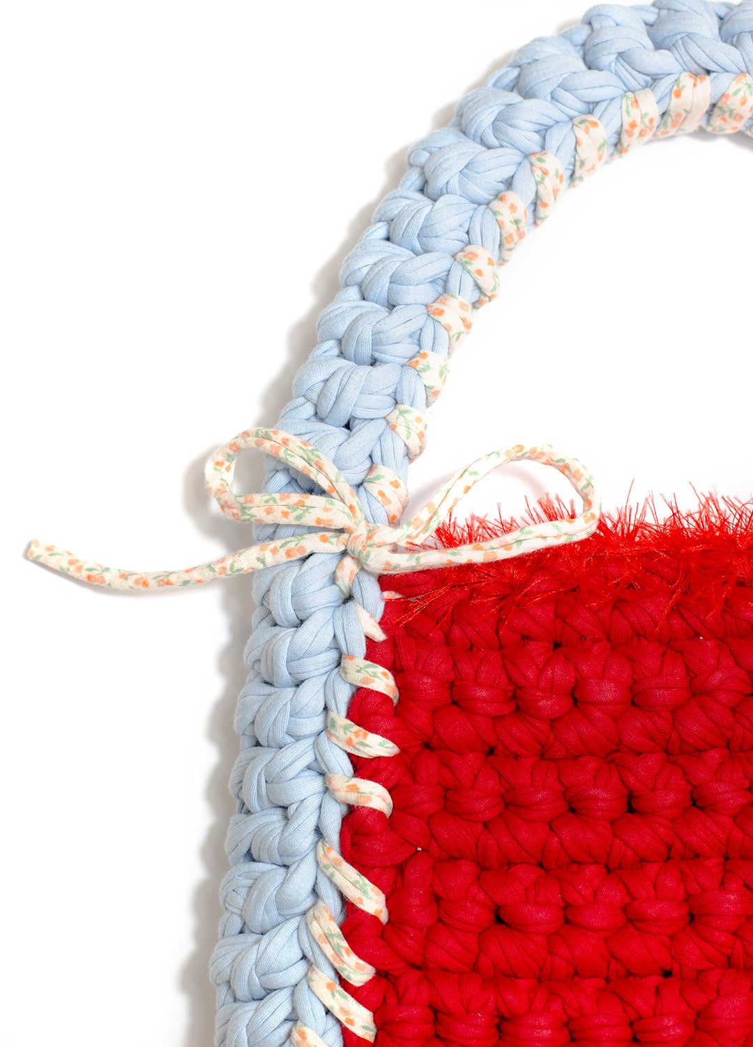 Close-up of a red and blue crocheted item with a white border.