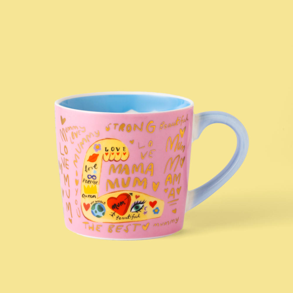 Pink mug with colorful text and designs on a yellow background